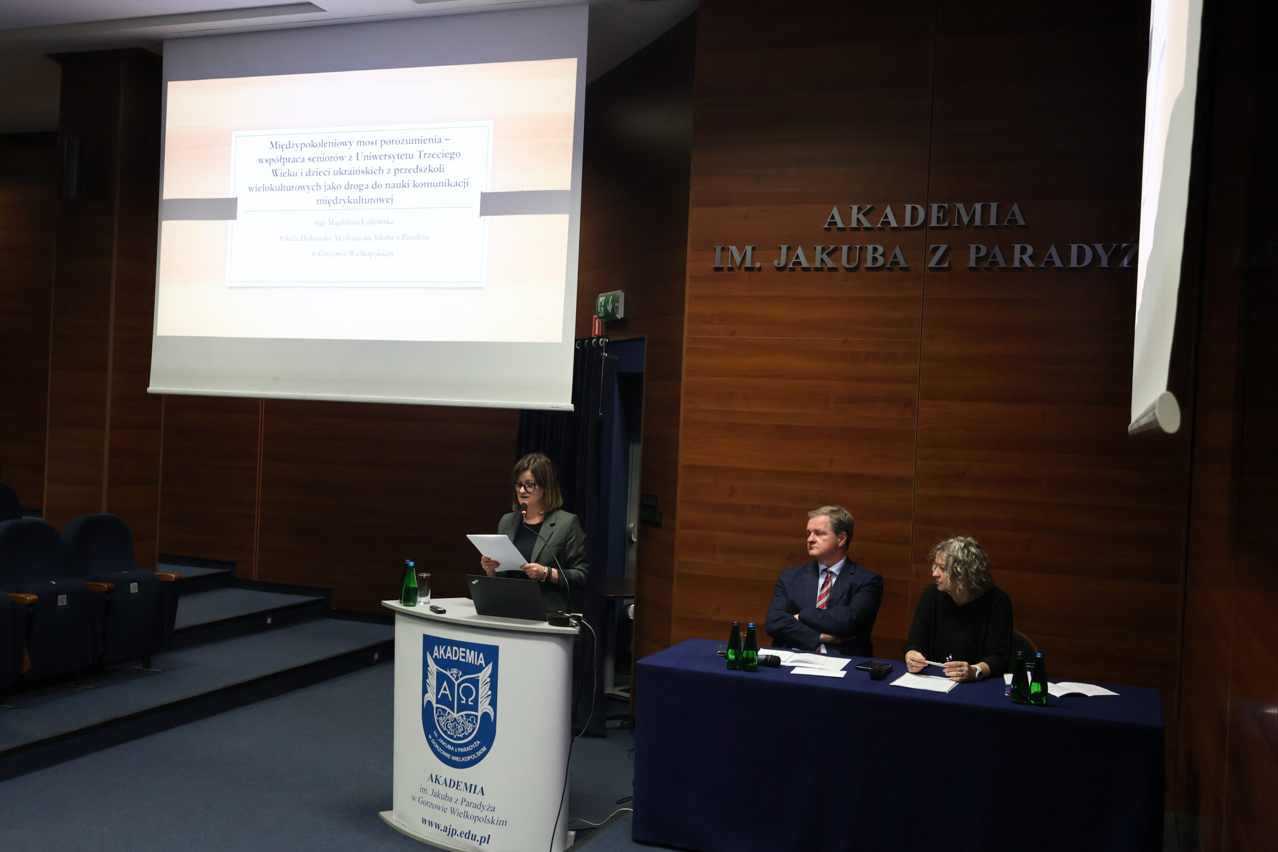 Na zdjęciu mgr Magdalena Łątkowska. Przy stole prezydialnym prof. dr hab. Grzegorz Kucharczyk i dr Ewa Koprowiak.