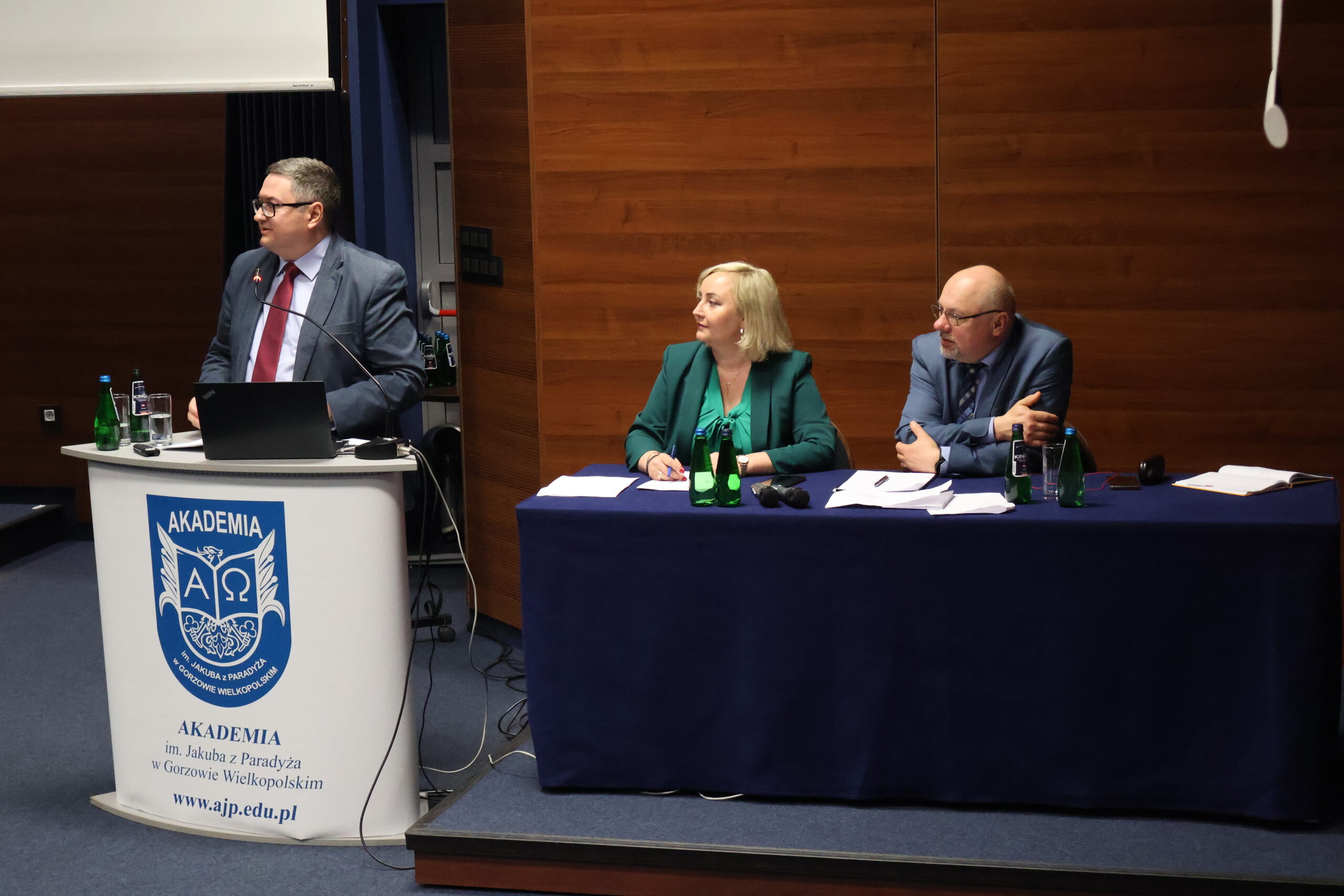Na zdjęciu dr hab. prof. AJP Marcin Wasilewski. Przy stole prezydialnym prof. AJP dr Małgorzata Trocka i prof. AJP dr Arkadiusz Wołoszyn.