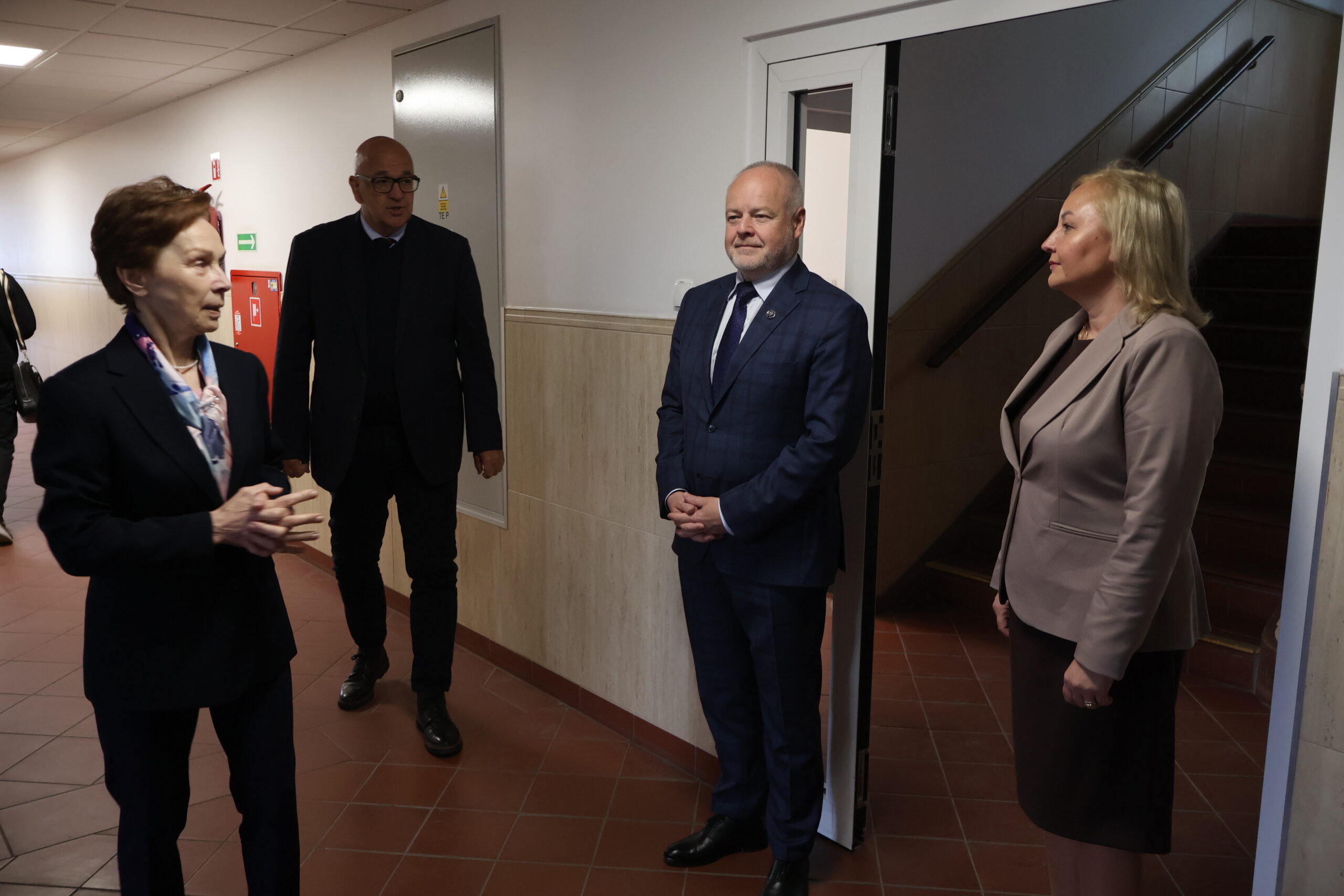 Na zdjęciu od prawej: Prorektor ds. Kształcenia prof. AJP dr Małgorzata Trocka, Sekretarz Stanu prof. dr hab. inż. Marek Gzik (Ministerstwo Nauki i Szkolnictwa Wyższego), Kanclerz AJP Roman Gawroniak,Rektor AJP prof. dr hab. Elżbieta Skorupska-Raczyńska na korytarzu budynku nr 6.