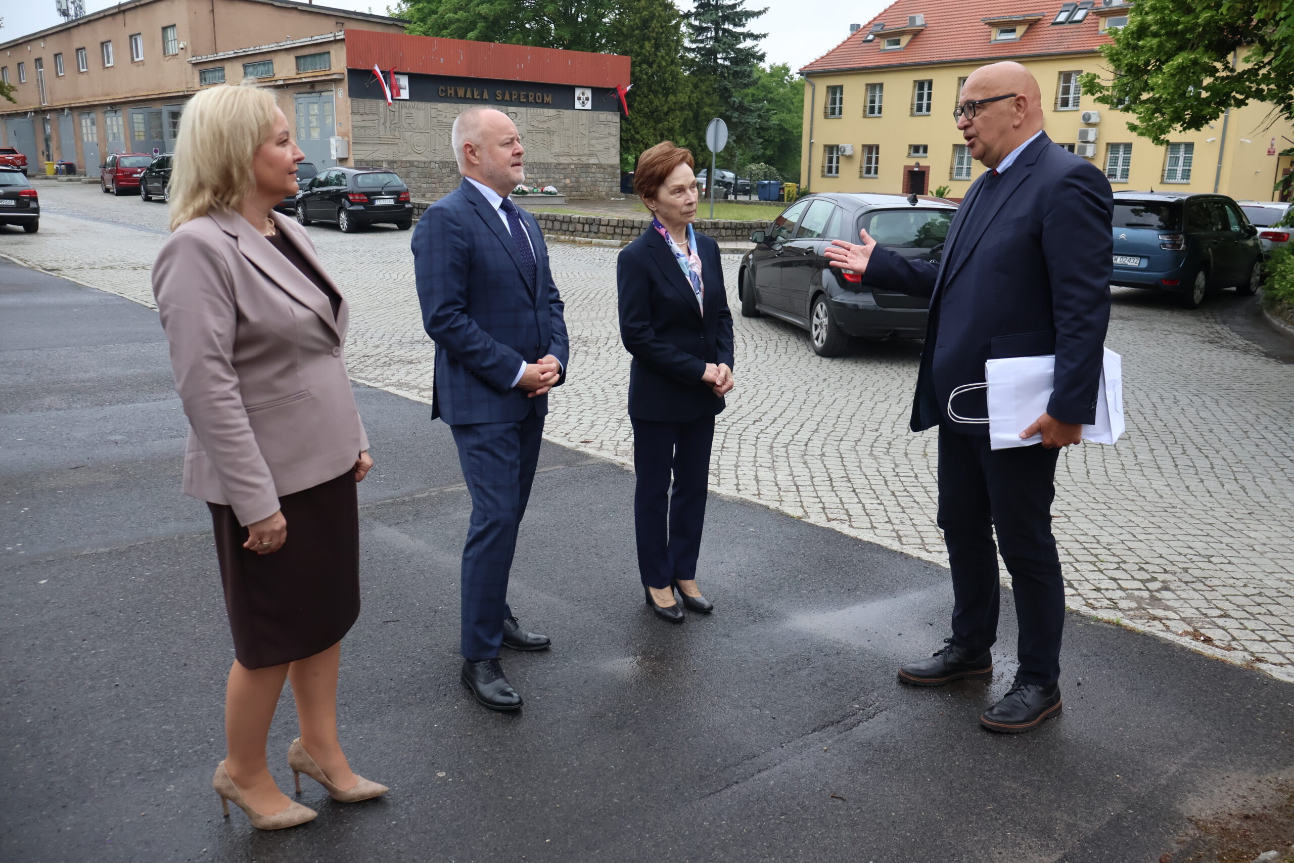 Na zdjęciu od prawej: Kanclerz mgr Roman Gawroniak, Rektor AJP prof. dr hab. Elżbieta Skorupska-Raczyńska, Sekretarz Stanu prof. dr hab. inż. Marek Gzik (Ministerstwo Nauki i Szkolnictwa Wyższego), Prorektor ds. Kształcenia prof. AJP dr Małgorzata Trocka na tle boiska i hali sportowej przy ul. Fryderyka Chopina 52.