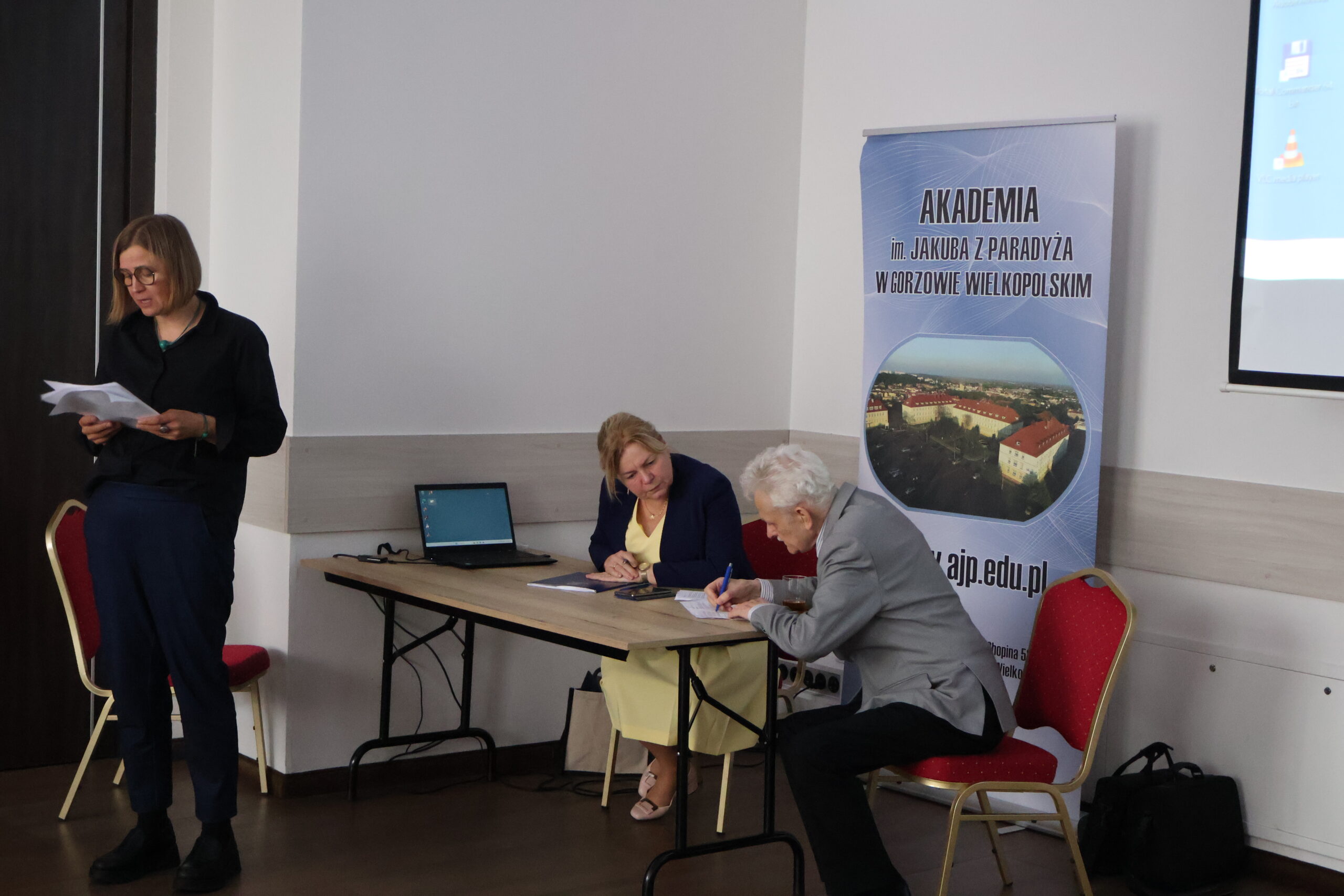 Na zdjęciu: prof. AJP dr hab. Magdalena Jaworska podczas wygłaszania referatu, przy stole prof. dr hab. Tadeusz Lewaszkiewicz i prof. AJP dr Jolanta Gebreselassie