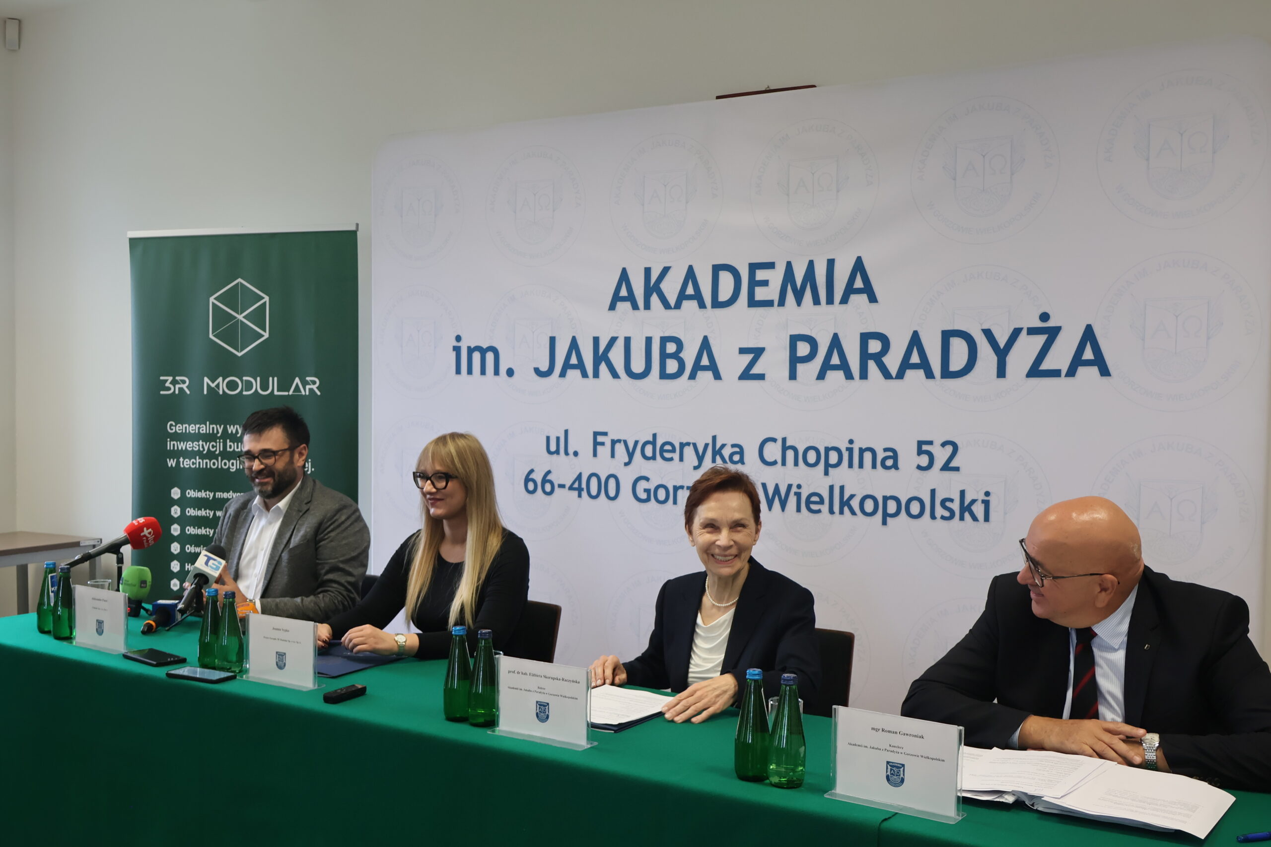 Na zdjęciu od prawej za stołem: mgr Roman Gawroniak, Rektor Akademii im. Jakuba z Paradyża - prof. dr hab. Elżbieta Skorupska-Raczyńska, Prezes Zarządu Wykonawcy 3R MODULAR Pani Joanna Sypko,Przedstawiciel firmy CLIMATIC Pan Aleksander Panek podczas podpisania umowy o budowę nowego budynku 3bis na terenie przy ul. Fryderyka Chopina 52. ,Przedstawiciel firmy CLIMATIC Pan Aleksander Panek wypowiada się do mediów.