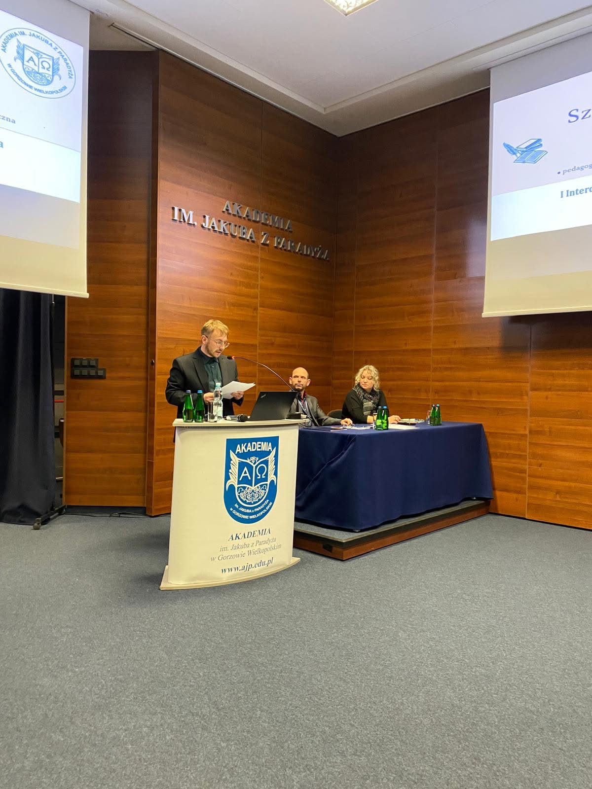 na zdjęciu: mgr Kamil Wrzesiński wygłasza referat, przy stole dr Ewa Koprowiak i mgr Mirosław Waszak