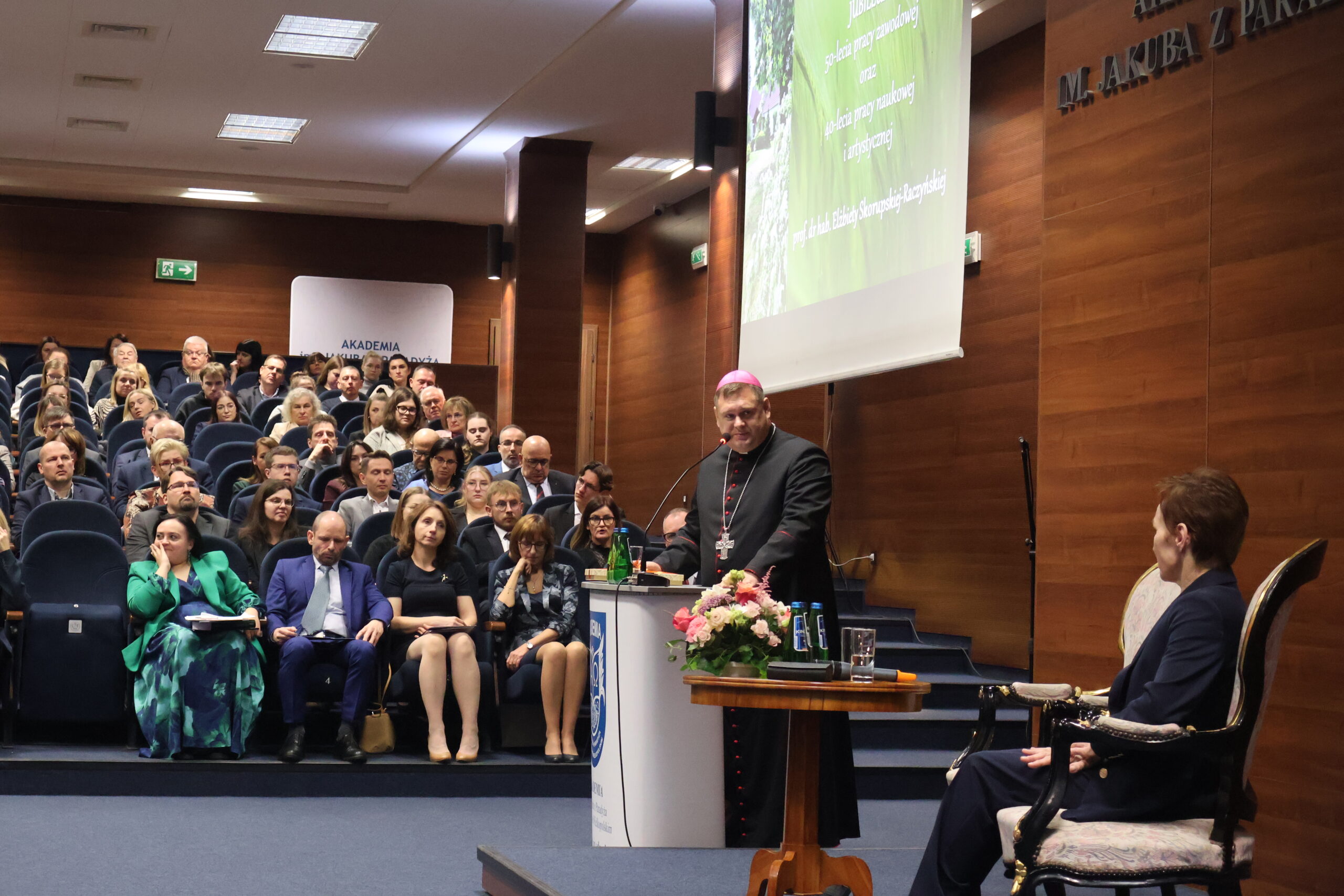 Na zdjęciu przemawia JE Biskup pomocniczy ks. dr Adrian Put oraz Rektor prof. dr hab. Elżbieta Skorupska-Raczyńska.