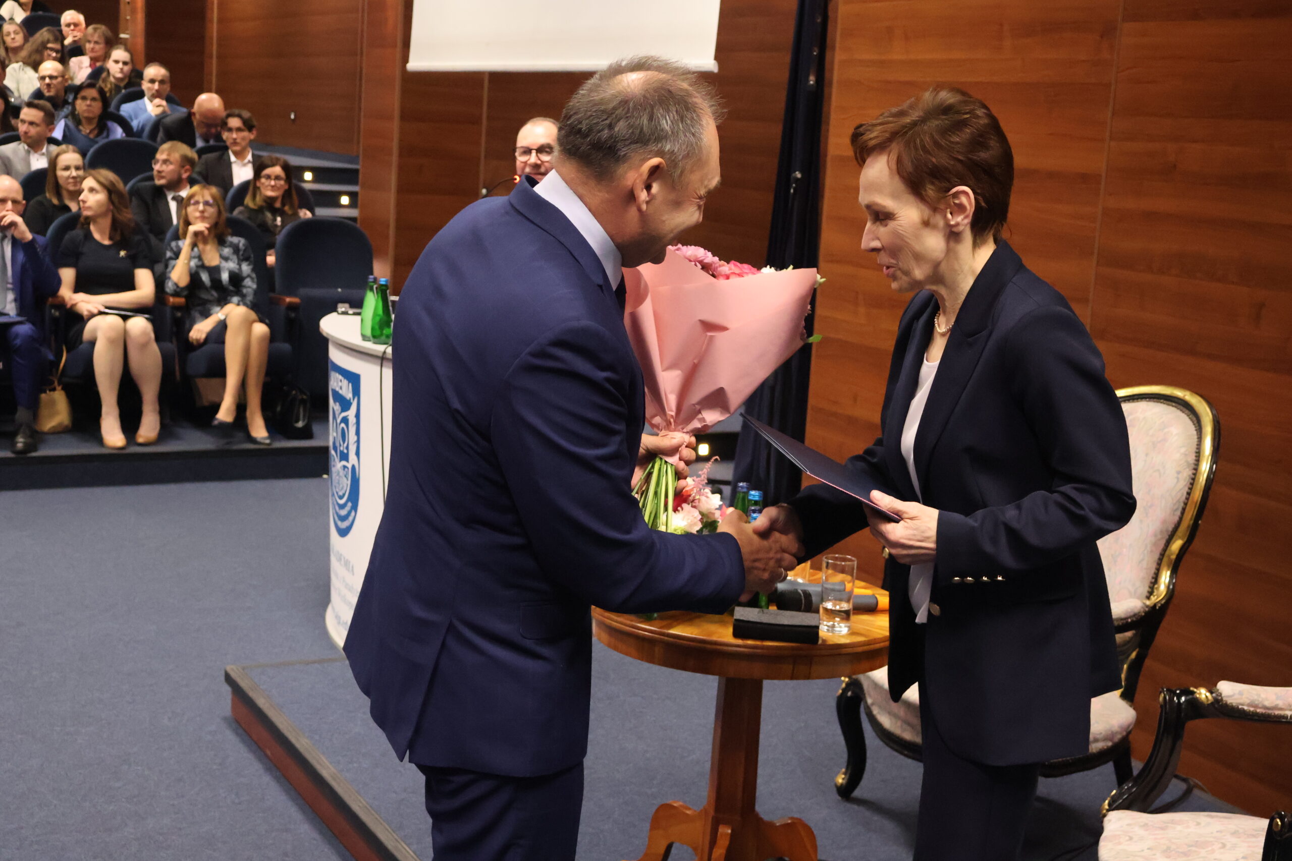 Na zdjęciu Przewodniczący Rady Uczelni Sławomir Klusek wręcza kwiaty JM Rektor.