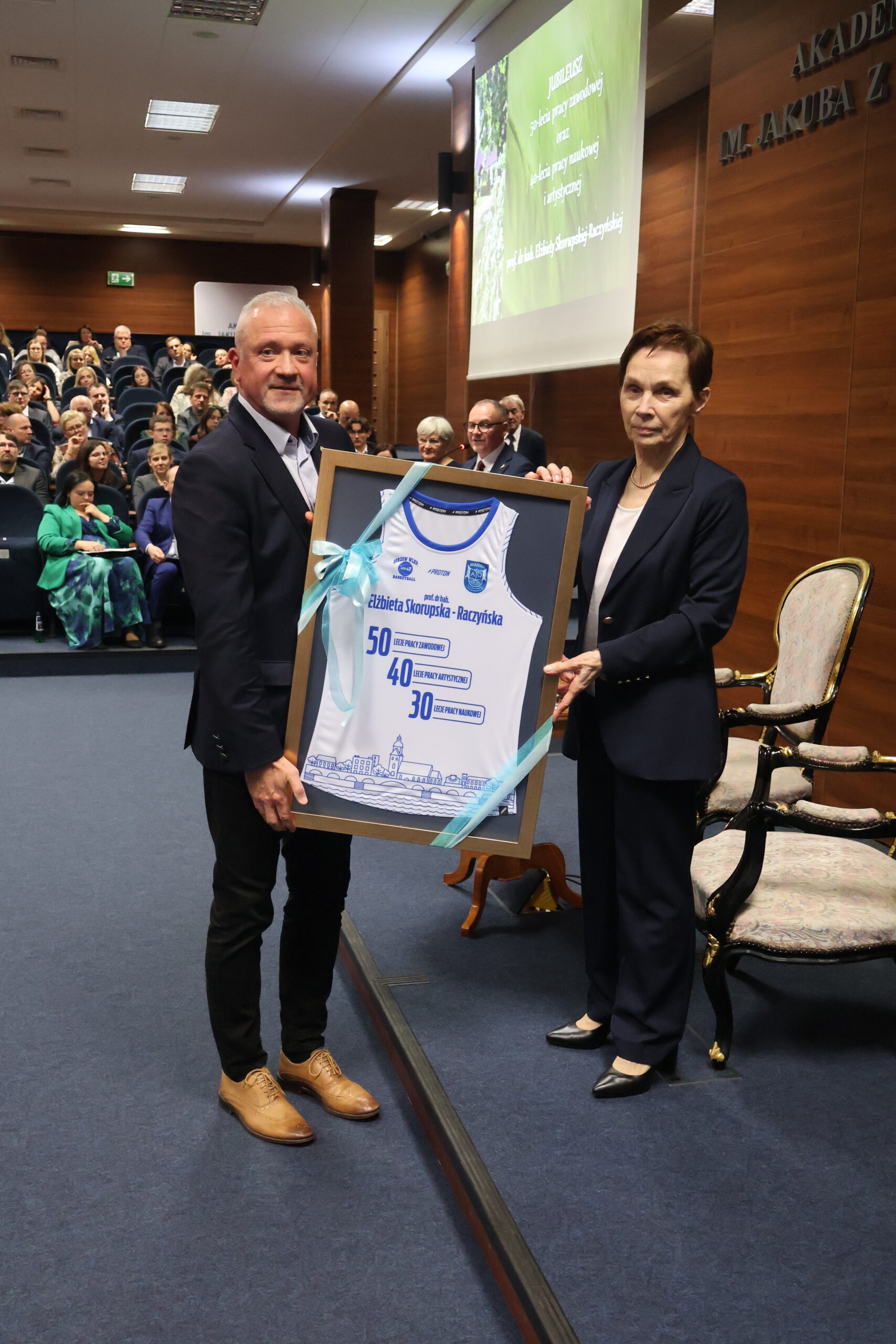 Na zdjęciu trener AZS AJP Dariusz Maciejewski oraz JM Rektor przy wręczonym prezencie.