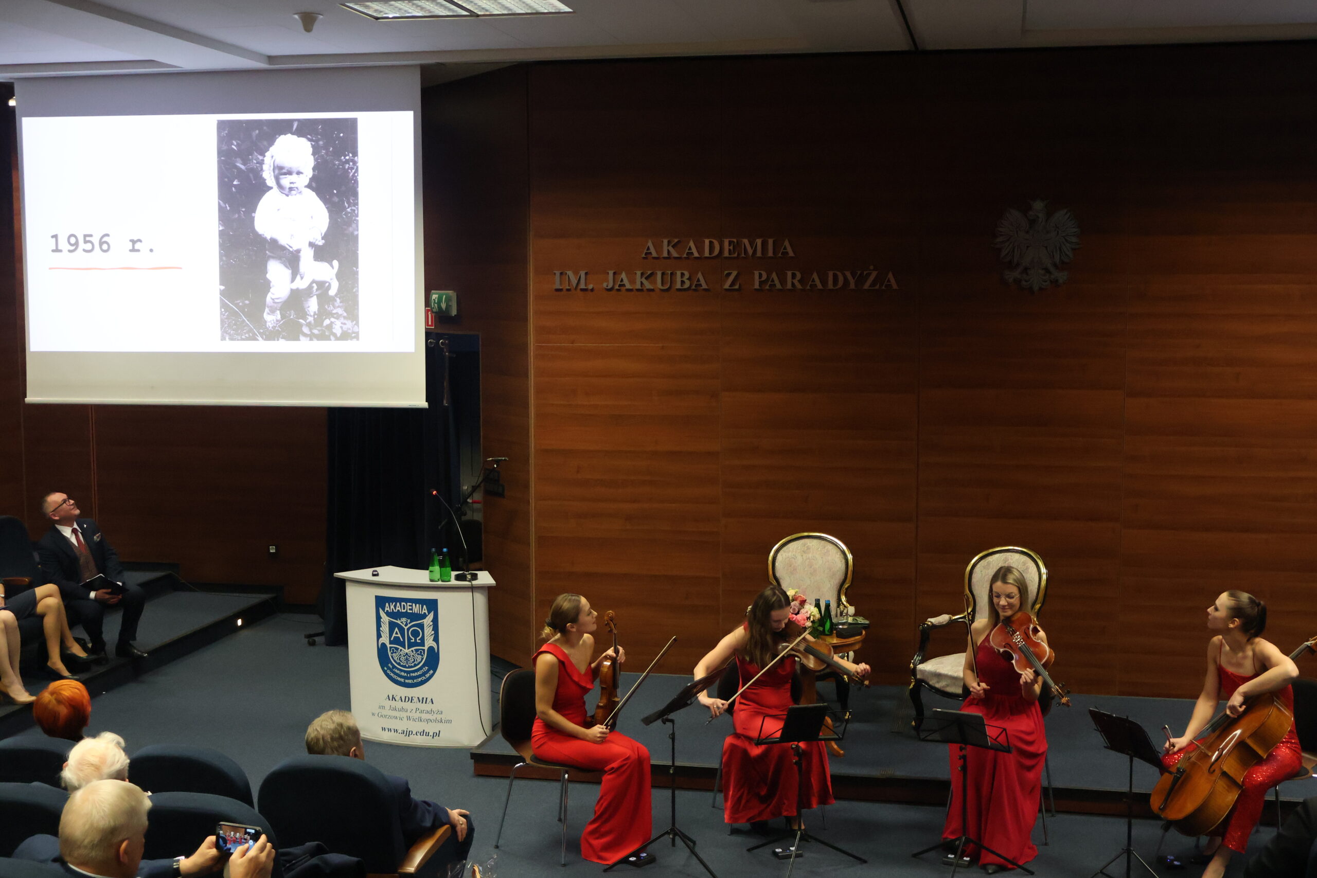 Na zdjęciu widać prezentację zdjęć ukazujących Panią Profesor od najmłodszych lat, a towarzyszyła temu muzyka kwartetu smyczkowego SONORE.