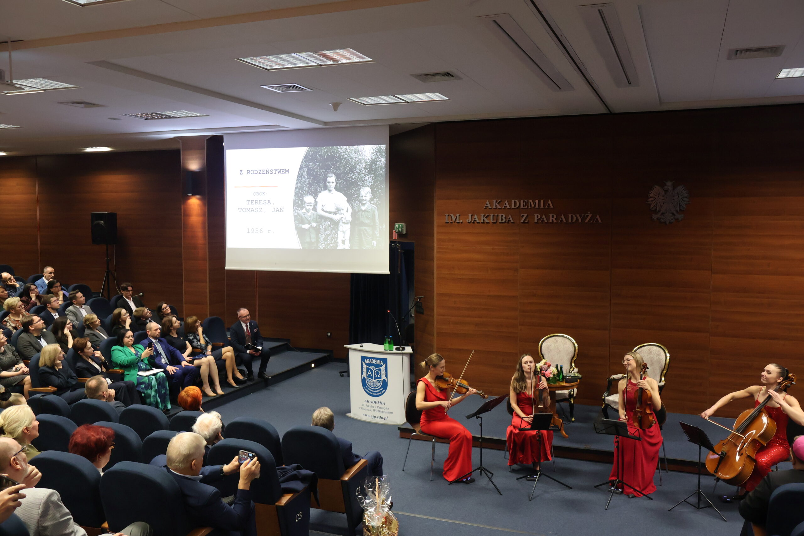 Na zdjęciu widać prezentację zdjęć ukazujących Panią Profesor od najmłodszych lat, a towarzyszyła temu muzyka kwartetu smyczkowego SONORE.