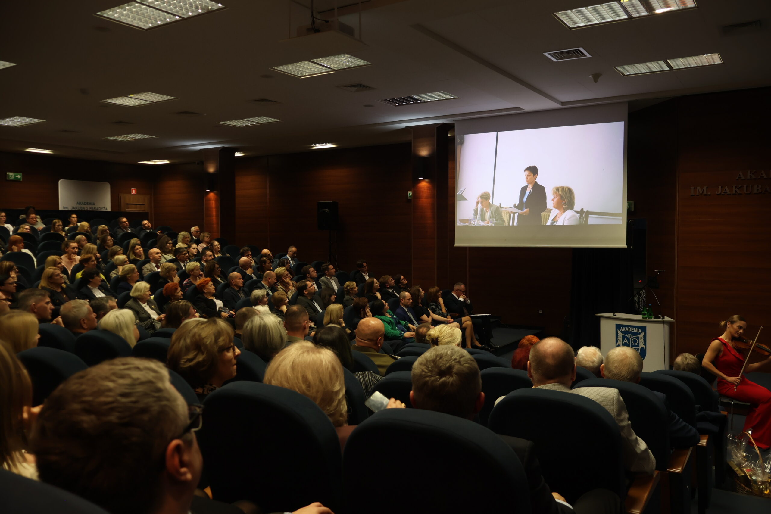 Na zdjęciu widać prezentację zdjęć ukazujących Panią Profesor od najmłodszych lat, a towarzyszyła temu muzyka kwartetu smyczkowego SONORE.