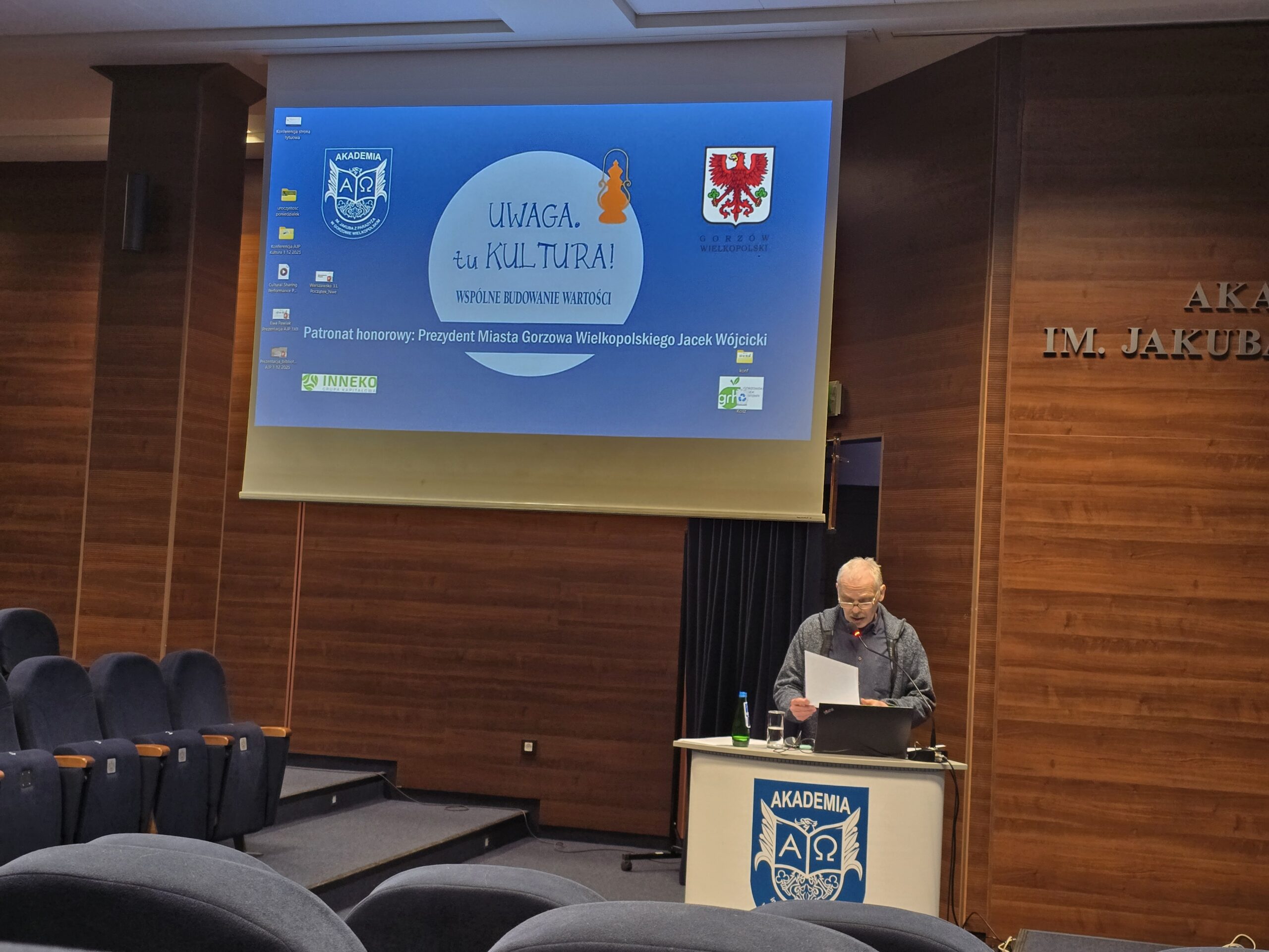 Mężczyzna stoi i czyta za mównicą podczas konferencji.