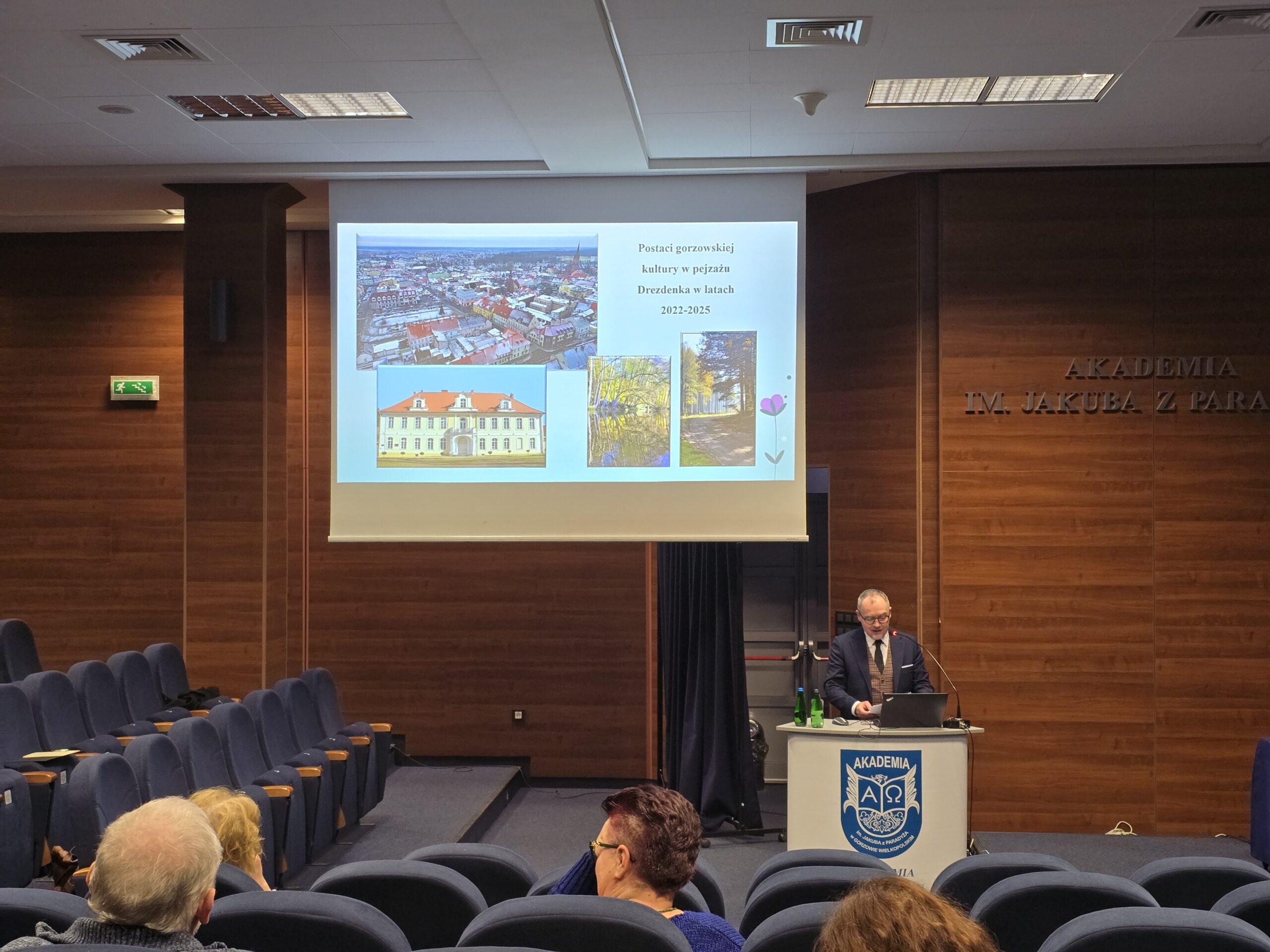 Wykładowca stoi za mównicą podczas konferencji.