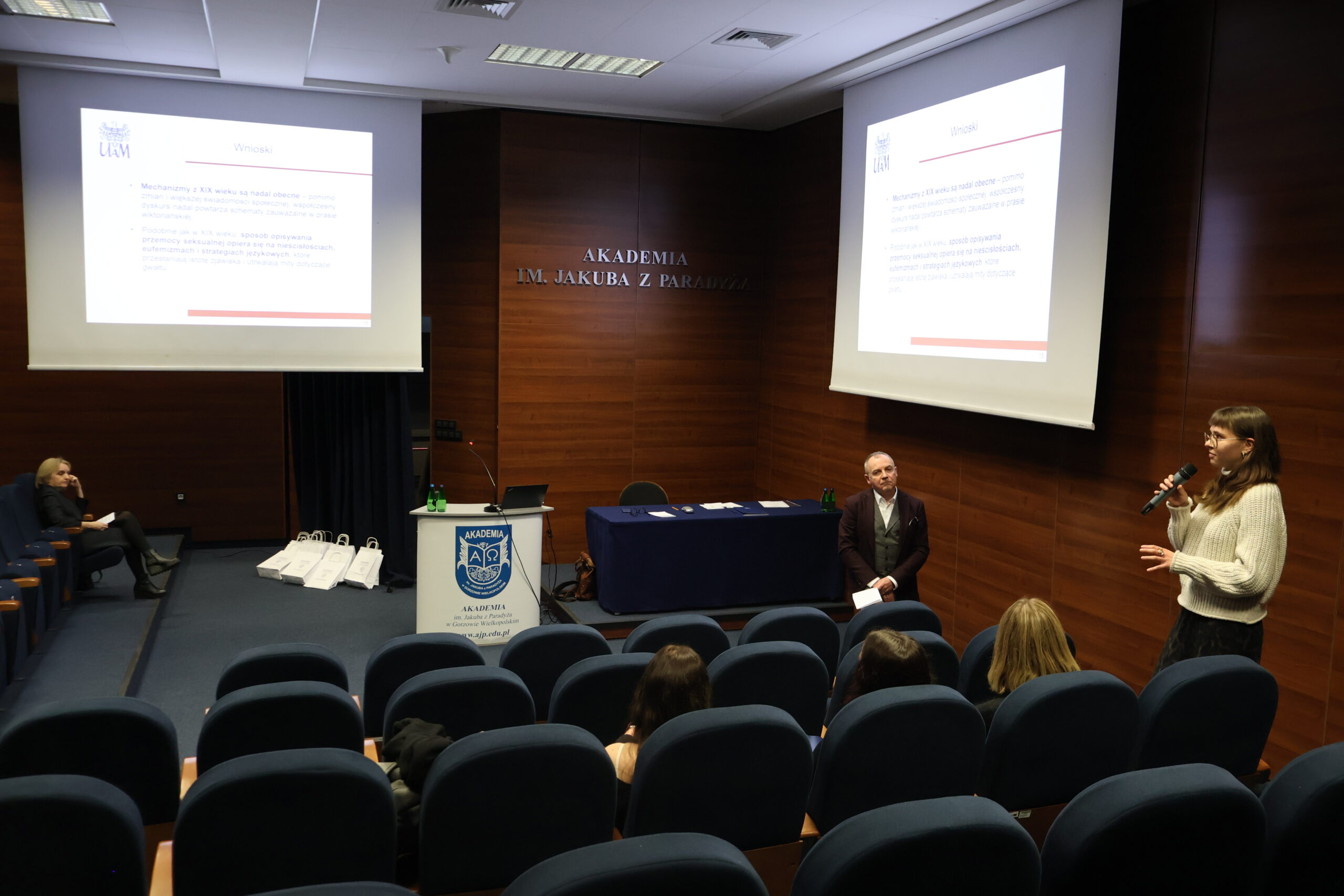 W panelu dyskusyjnym po zakończonej konferencji prelegentka odpowiada na zadane pytanie przez dr Renatę Janicką-Szyszko, w tle dr Wojciecha Kuski przysłuchuje się.