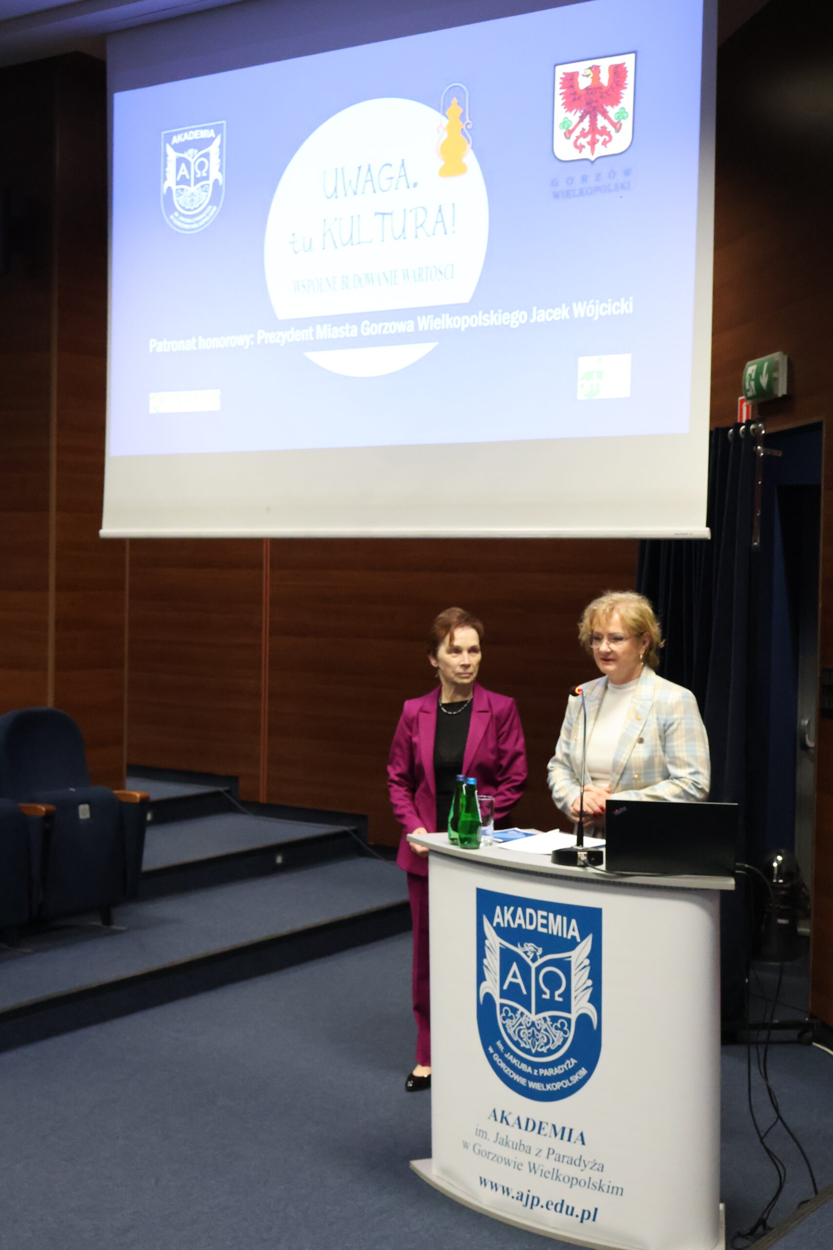 Po lewej stoi Pani Rektor, a po prawej za mównicą stoi kobieta.