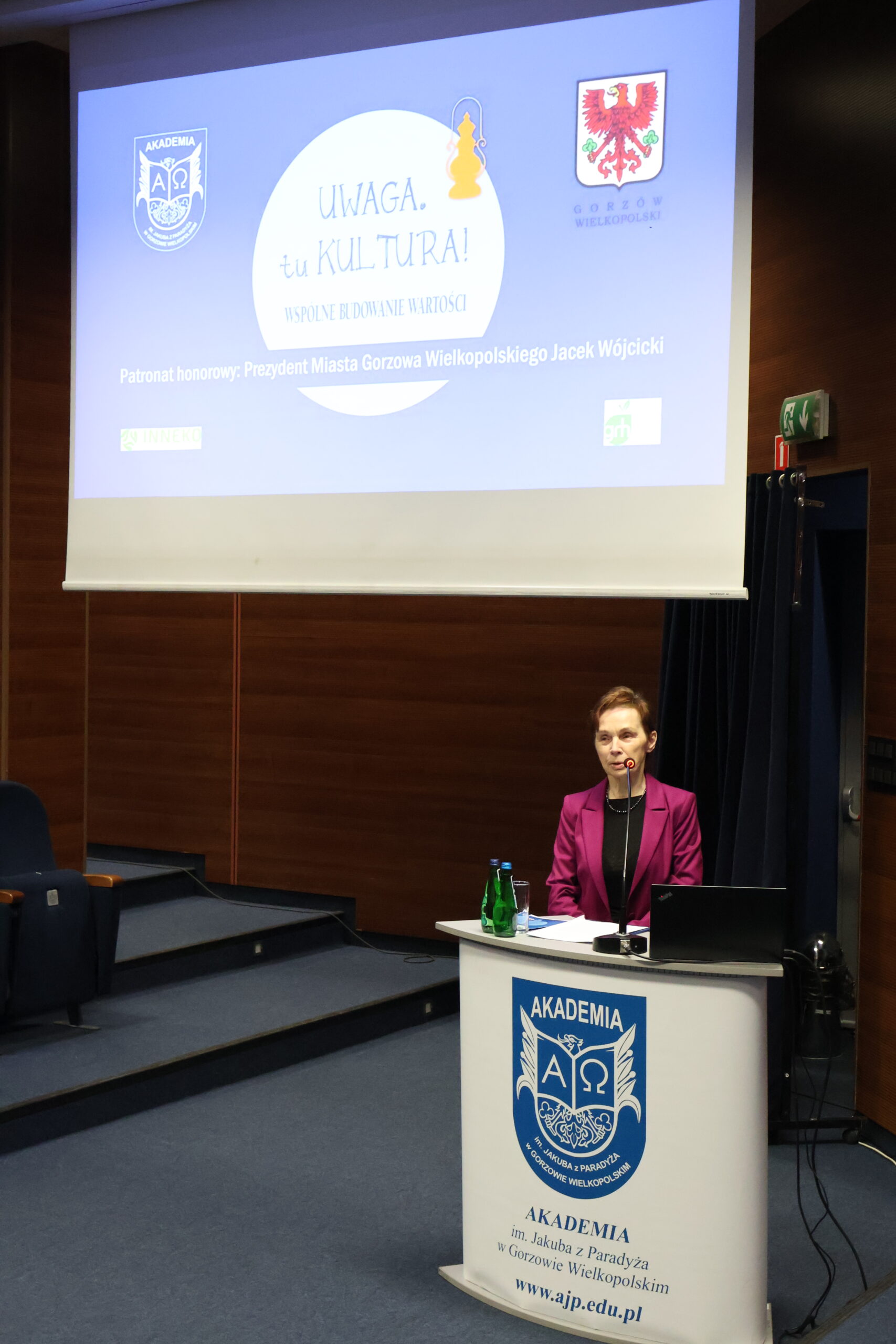 Pani Rektor stoi za mównicą podczas konferencji.