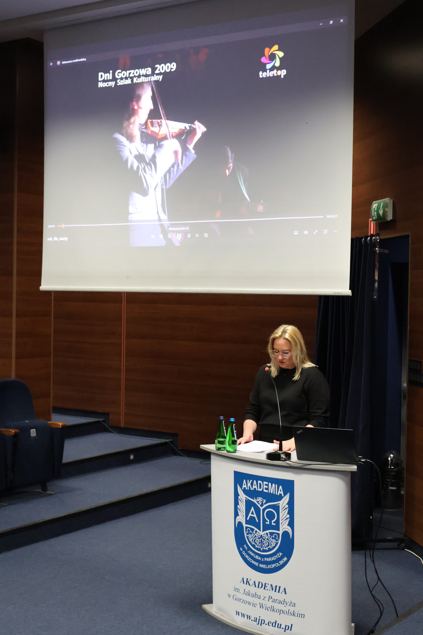 Kobieta stoi za mównicą podczas konferencji.