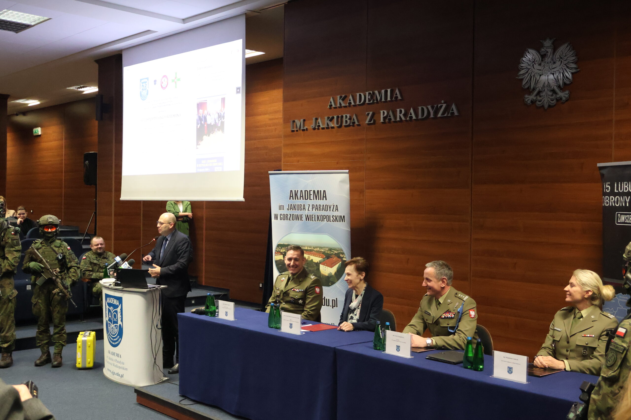 W imieniu imieniu Wojewody Lubuskiego Pana Marka Cebuli głos zabrał Dyrektor Generalny Lubuskiego Urzędu Wojewódzkiego Pan Radosław Wróblewski widoczny za mównicą, przy stole prezydialnym od lewej: mjr rez. mgr dypl. Robert Urbanek, prof. dr hab. Elżbieta Skorupska-Raczyńska, płk Leszek Giergielewicz i major Magdalena Goliszek.