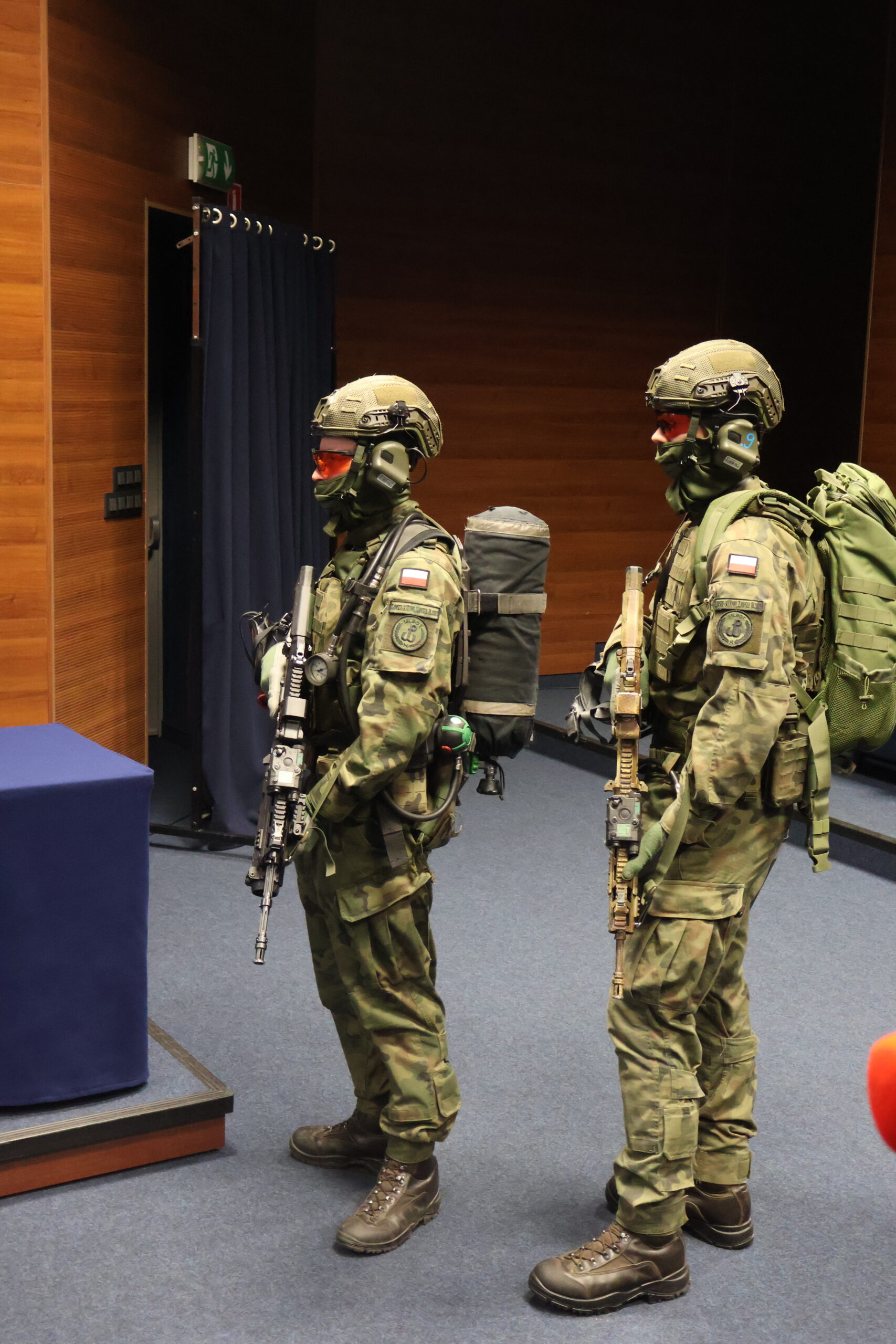 Żolnierze 15LBOT w mundurach wojskowych z karabinami w auli im. prof. Stanisława Kirkora