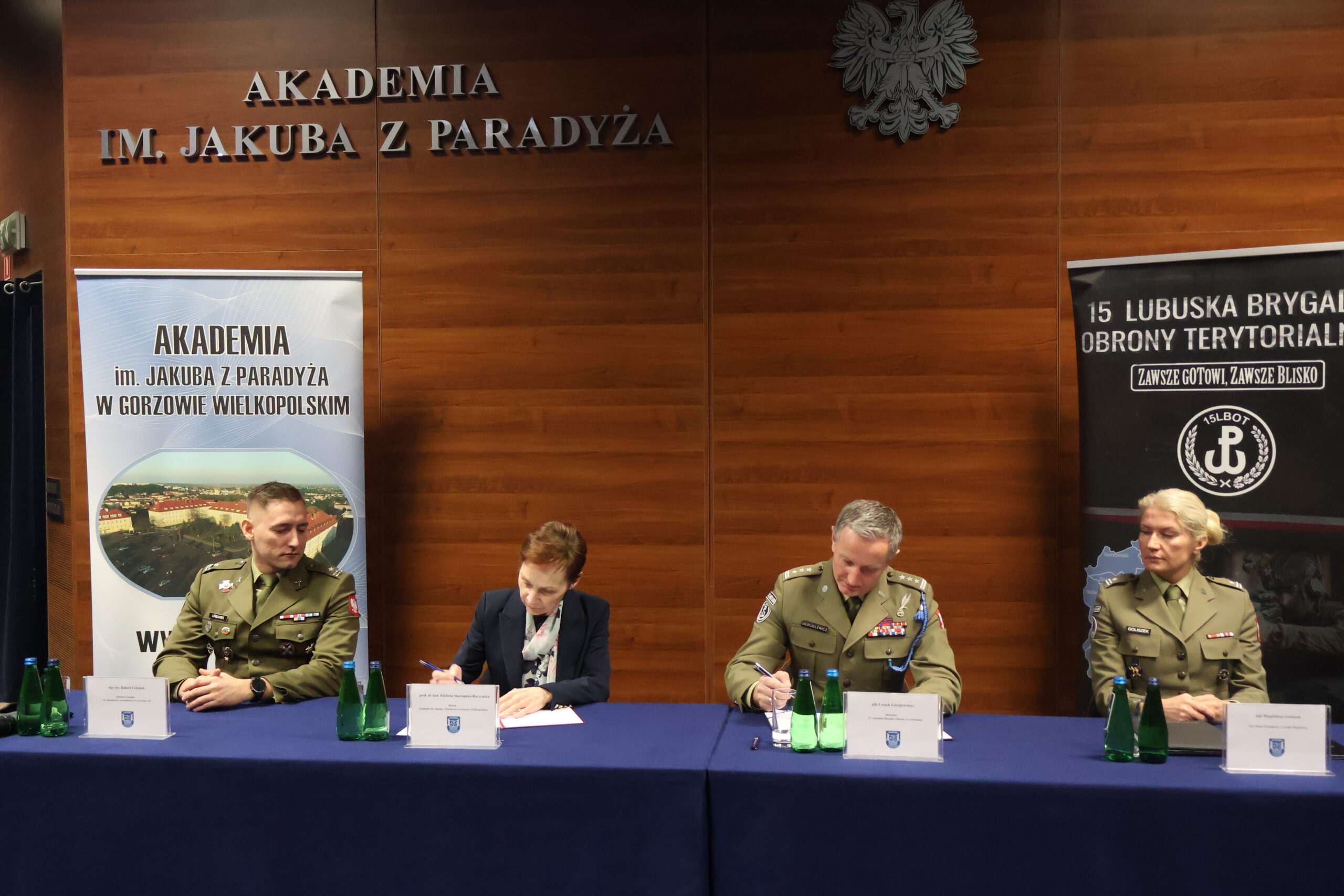 Płk Leszek Giergielewicz ( po prawej) i prof. dr hab. Elżbieta Skorupska-Raczyńska (po lewej) w trakcie aktu uroczystego podpisania porozumienia pomiędzy 15 LBOT a AJP w towarzystwie obecnych: mjr rez. mgr dypl. Roberta Urbanka i majora Magdaleny Goliszek.