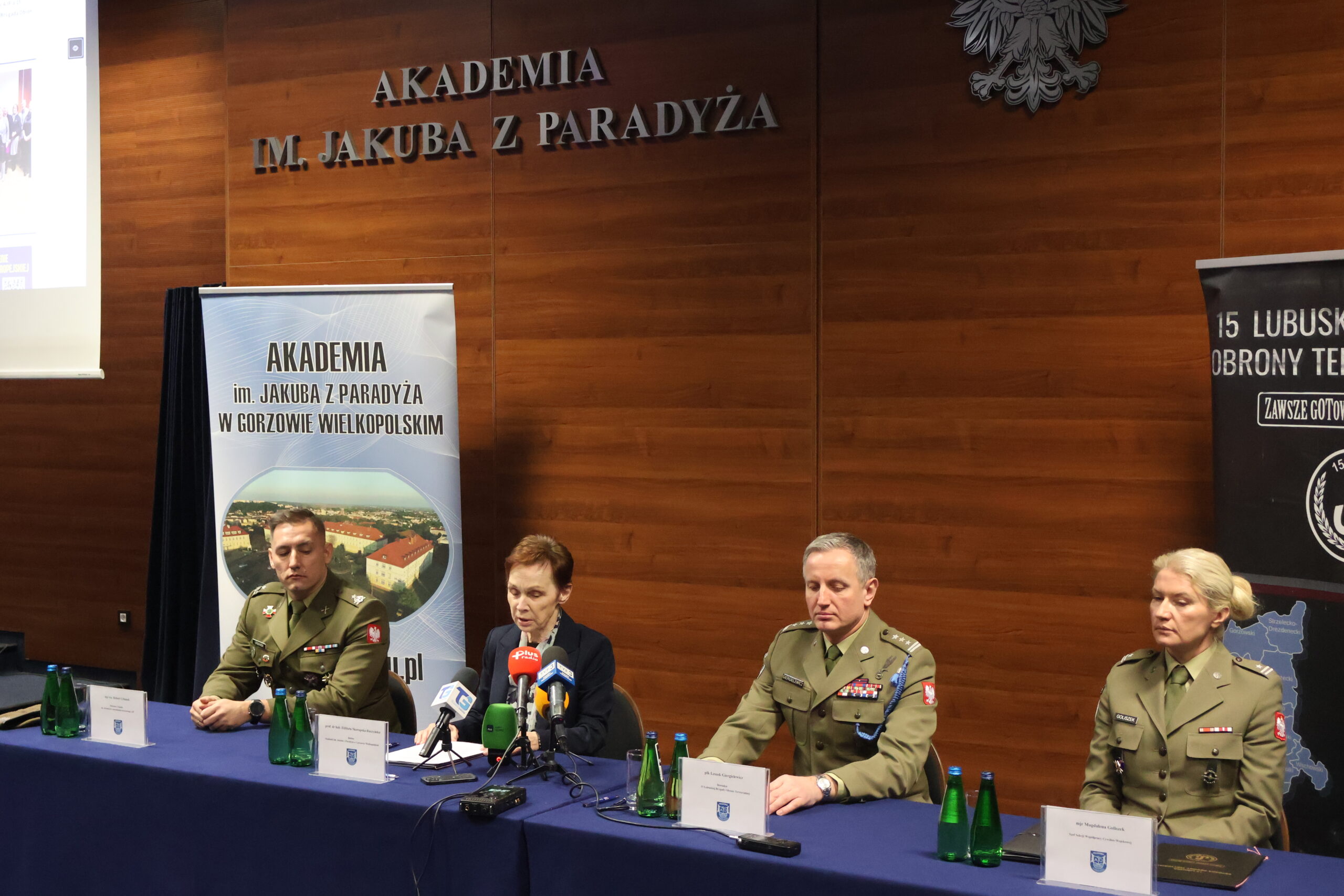 W auli im. prof. Stanisława Kirkora za stołem prezydialnym udziela odpowiedzi na zadane pytania przez media - prof. dr hab. Elżbieta Skorupska-Raczyńska, po lewej: mjr rez. mgr dypl. Robert Urbanek, a po prawej płk Leszek Giergielewicz, Dowódca 15 Lubuskiej Brygady Obrony Terytorialnej i major Magdalena Goliszek.