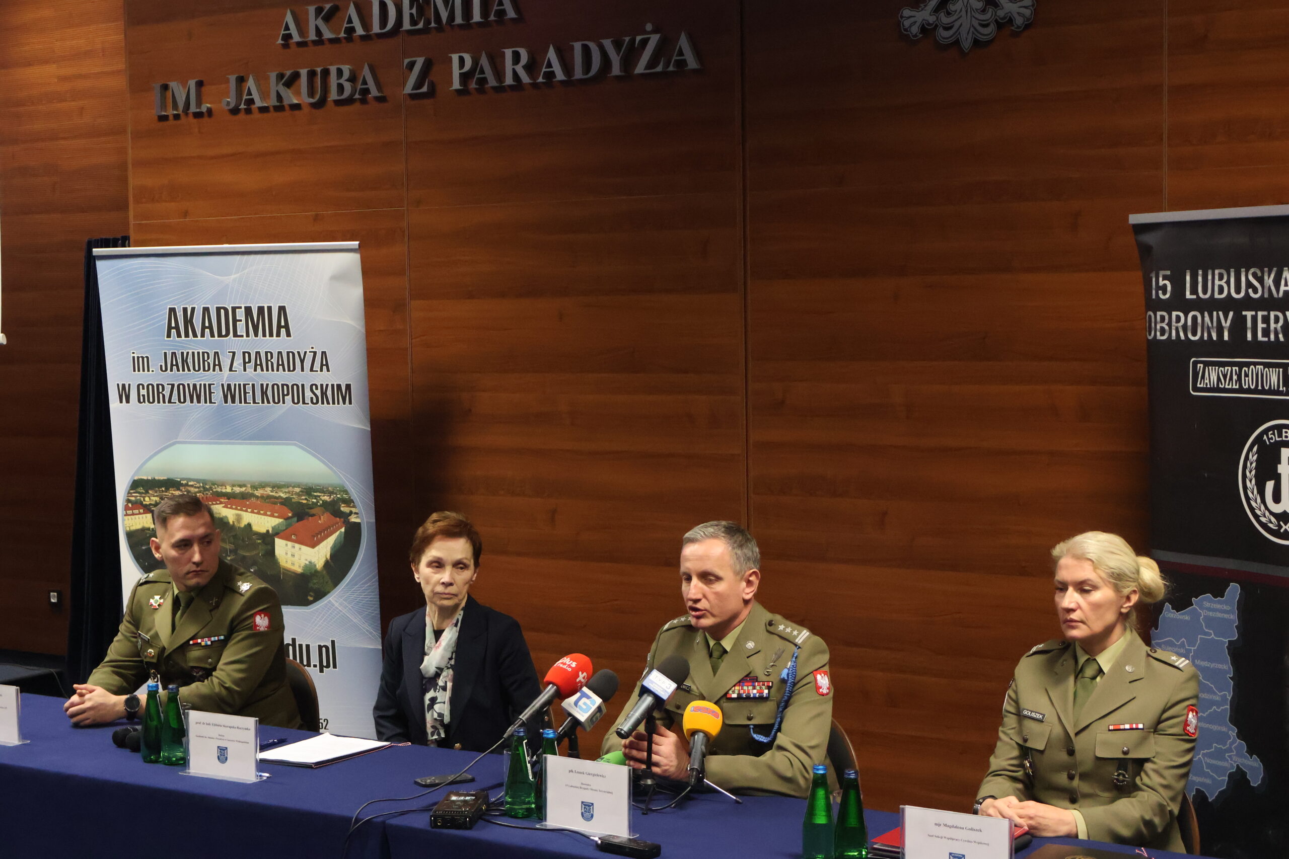 W auli im. prof. Stanisława Kirkora za stołem prezydialnym udziela odpowiedzi na zadane pytania przez media - płk Leszek Giergielewicz, Dowódca 15 Lubuskiej Brygady Obrony Terytorialnej. Obok niego po lewej prof. dr hab. Elżbieta Skorupska-Raczyńska, mjr rez. mgr dypl. Robert Urbanek, a po prawej major Magdalena Goliszek.