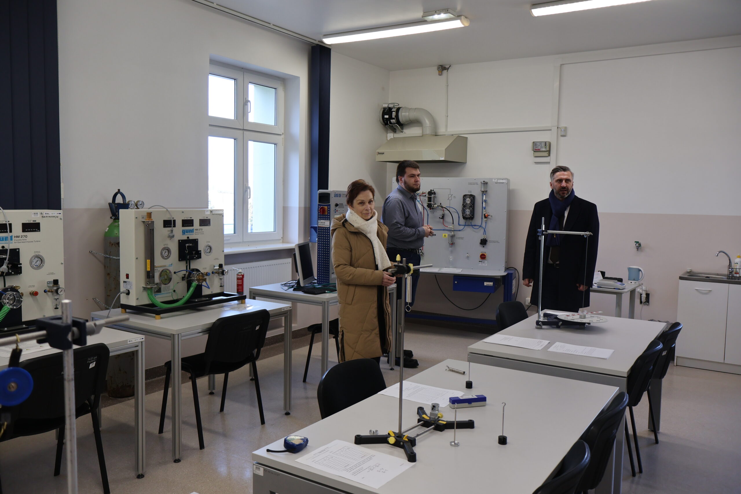 Od lewej: JM Rektor prof. dr hab. Elżbieta Skorupska-Raczyńska Laborant Jan Kołaciński przy maszynie oraz poseł na Sejm RP prof. UZ dr hab. Waldemar Sługocki podczas wizyty w jednym laboratoriów w budynku nr 7.