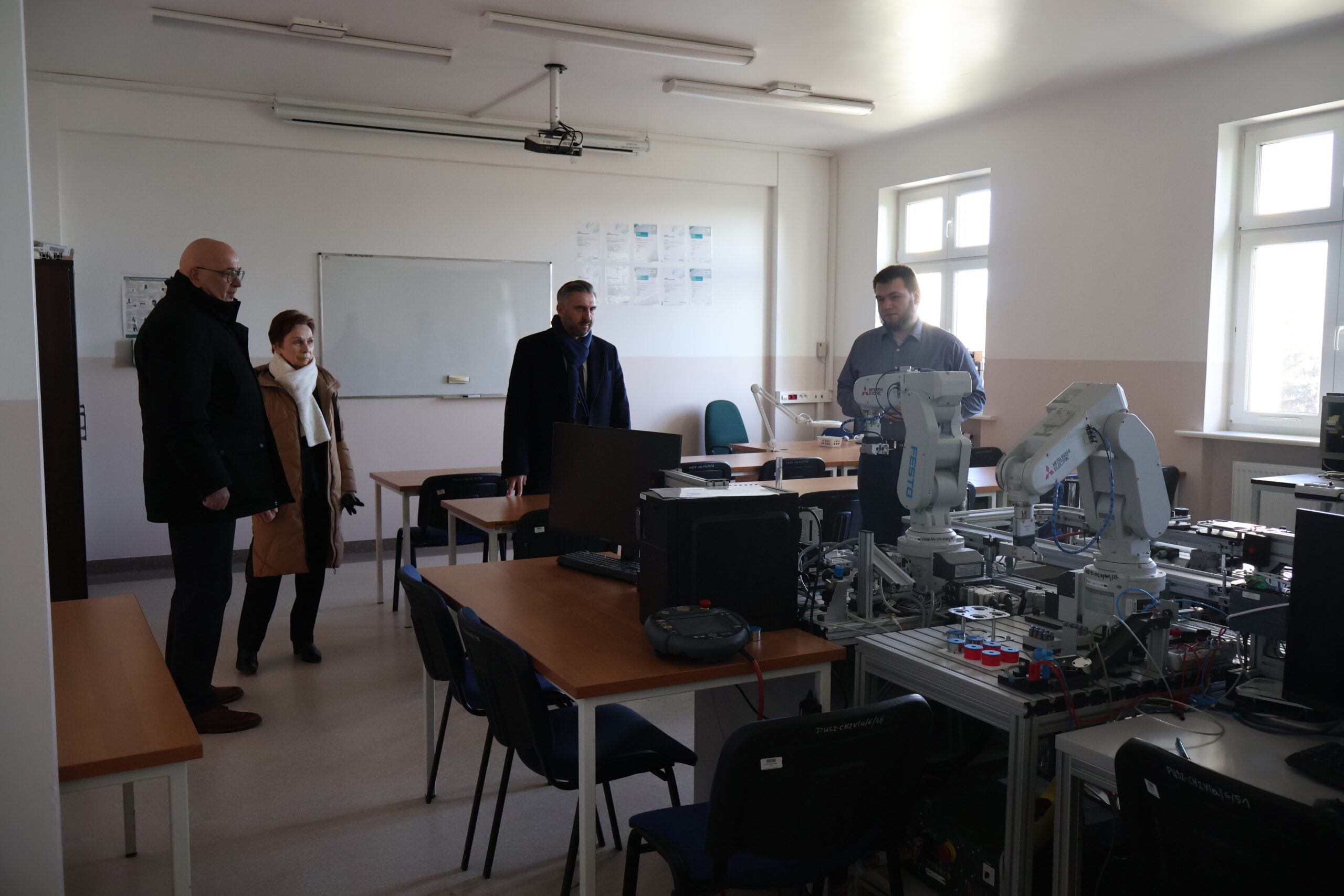 Od lewej: Kanclerz Uczelni mgr Roman Gawroniak, JM Rektor prof. dr hab. Elżbieta Skorupska-Raczyńska, poseł na Sejm RP prof. UZ dr hab. Waldemar Sługocki oraz laborant Jan Kołaciński podczas wizyty w jednym z gabinetów automatyki i robotyki w budynku nr 7