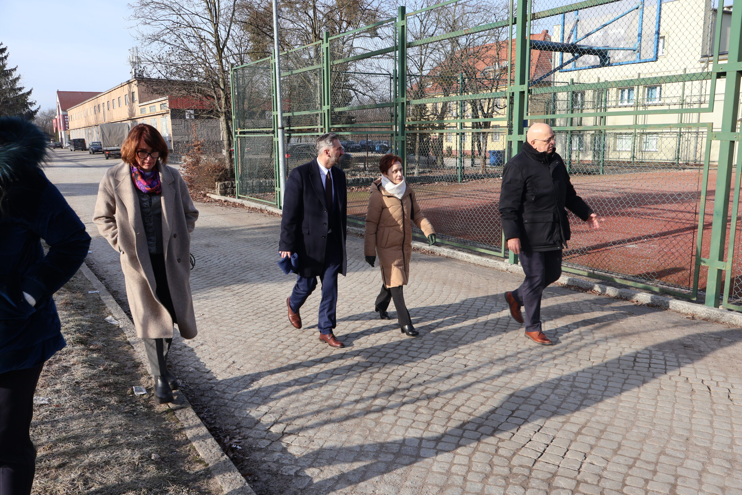 Od prawej: dr Joanna Kuriańska-Wołoszyn Prodziekan Wydziału Nauk o Zdrowiu, poseł na Sejm RP prof. UZ dr hab. Waldemar Sługocki, JM Rektor prof. dr hab. Elżbieta Skorupska-Raczyńska, Kanclerz Uczelni mgr Roman Gawroniak w drodze do budynku nr 5 bis przechadzając się obok boiska i hali sportowej.