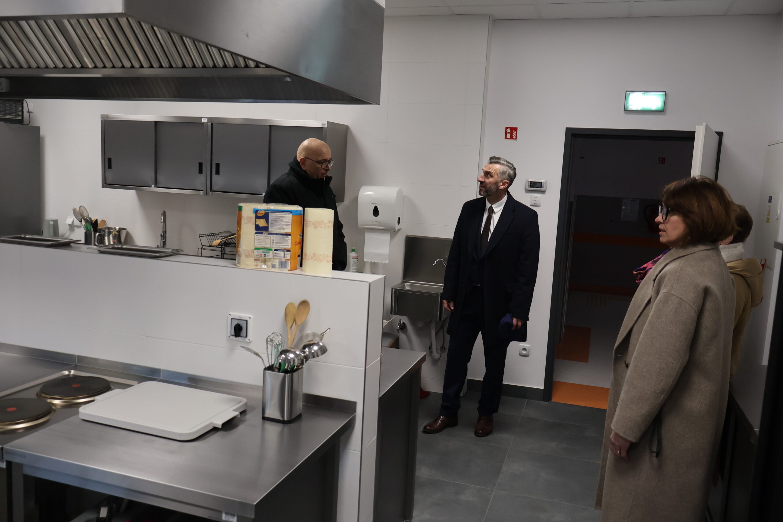 Po prawej na pierwszym planie stoi dr Joanna Kuriańska-Wołoszyn Prodziekan Wydziału Nauk o Zdrowiu, na drugim planie JM Rektor prof. dr hab. Elżbieta Skorupska-Raczyńska, po lewej poseł na Sejm RP prof. UZ dr hab. Waldemar Sługocki, a obok Kanclerz Uczelni mgr Roman Gawroniak apokazujący posłowi infrastrukturę Uczelni - kuchnie dla studentów dietetyki na budynku nr 5 bis.