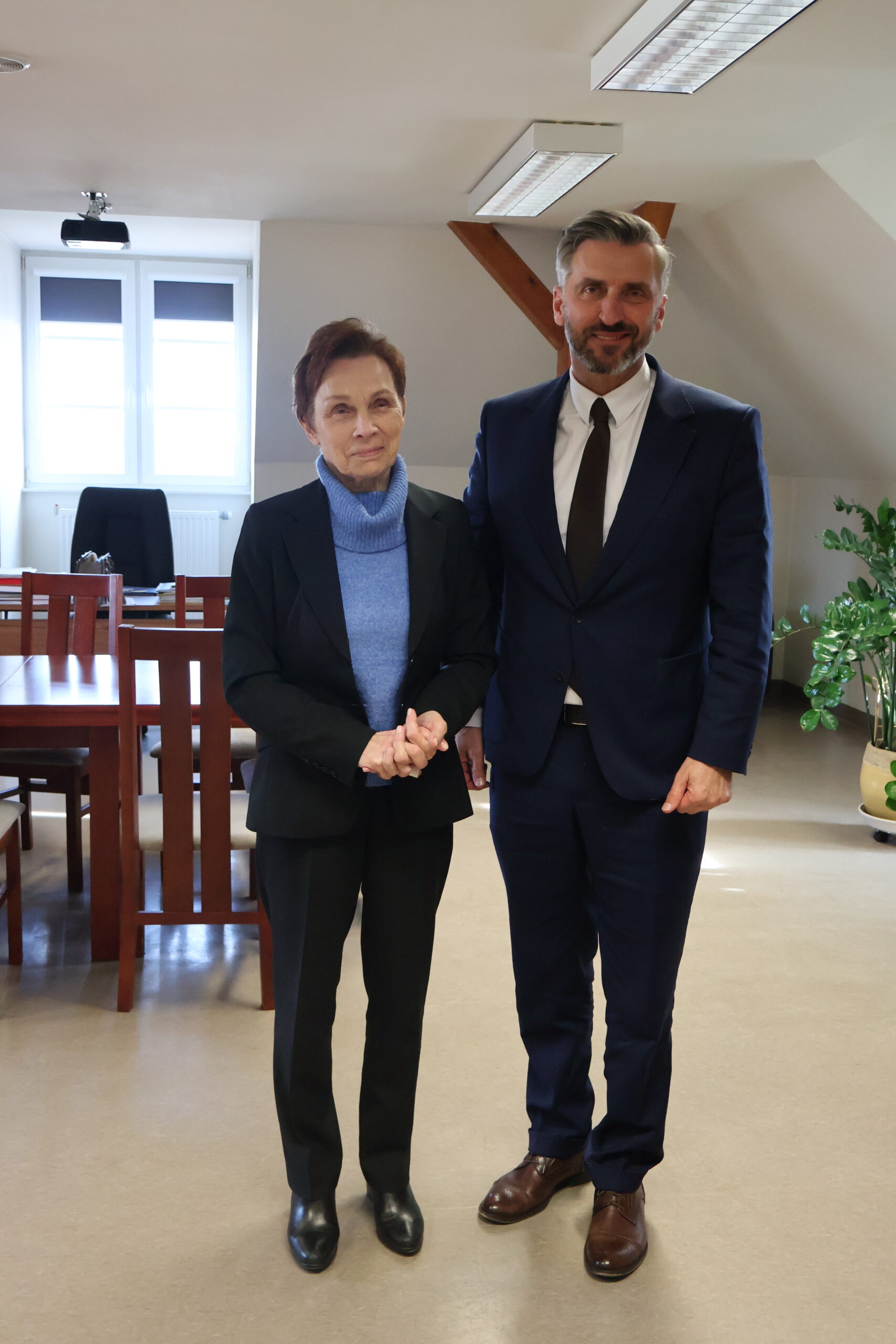 Po lewej na pierwszym planie stoi JM Rektor prof. dr hab. Elżbieta Skorupska-Raczyńska, po prawej poseł na Sejm RP prof. UZ dr hab. Waldemar Sługocki. w gabinecie Rektor podczas spotkania.
