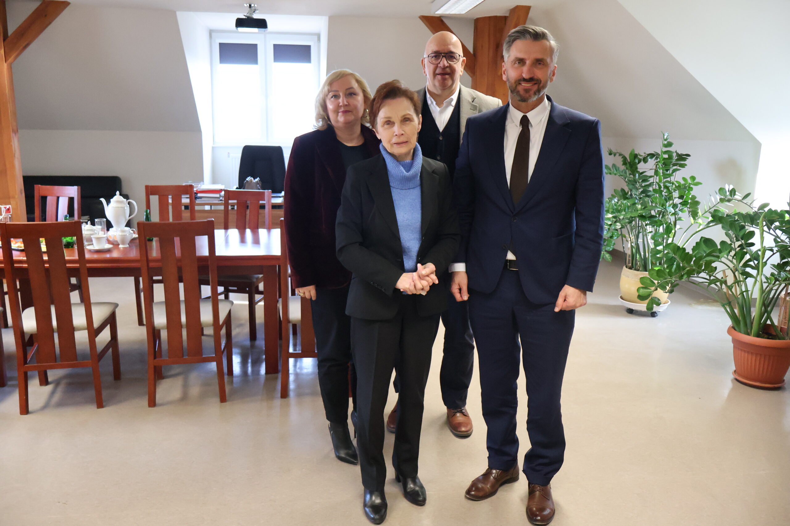 Po lewej na pierwszym planie stoi JM Rektor prof. dr hab. Elżbieta Skorupska-Raczyńska, po prawej poseł na Sejm RP prof. UZ dr hab. Waldemar Sługocki, na drugim planie po lewej Prorektor ds. Kształcenia prof. AJP dr Małgorzata Trocka, po lewej Kanclerz Uczelni mgr Roman Gawroniak w gabinecie Rektor podczas spotkania.