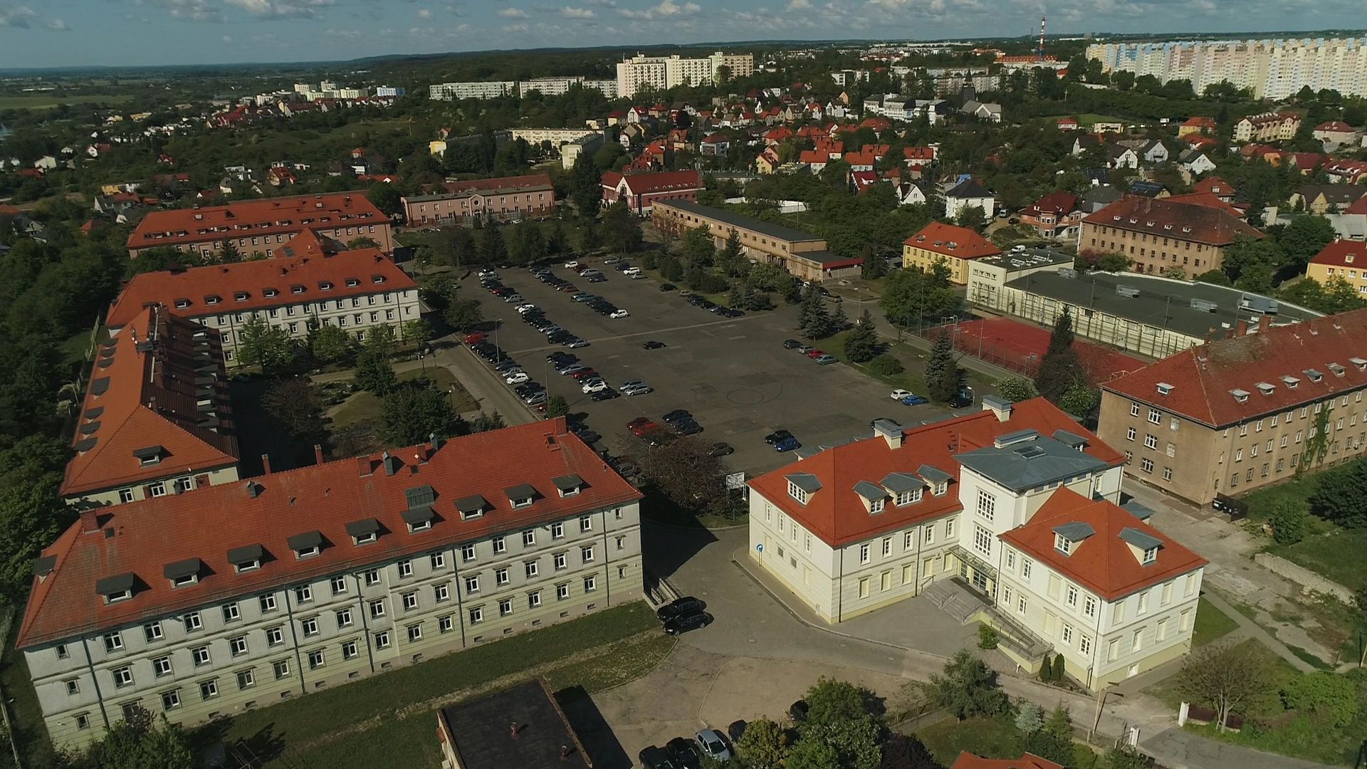 Widok z góry na kompleks budynków przy ul. Chopina 52, halę sportową i parking.