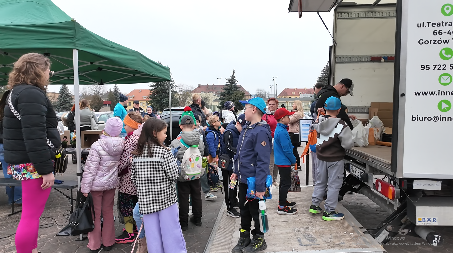 Grupa osób oddaje elektrośmieci przy ciężarówce.