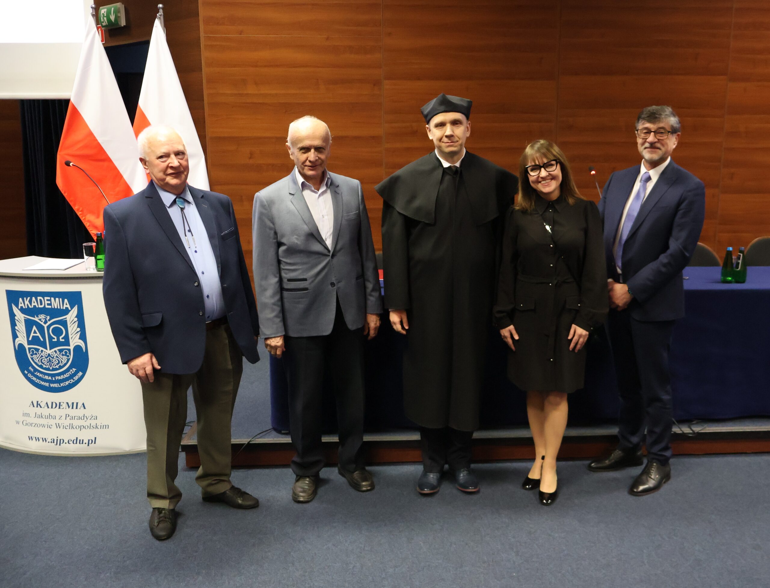 Stoi 5 osób: czterech mężczyzn i kobieta