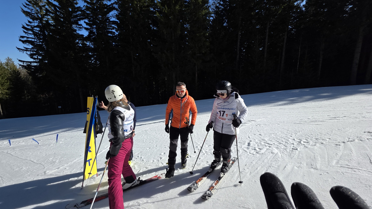 Trzech uczestników zawodów na stoku.