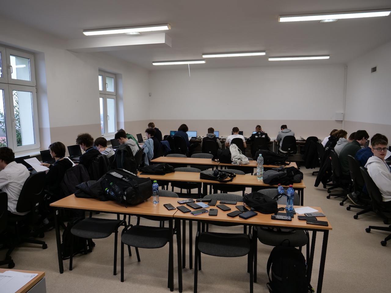 Uczestnicy siedzą przy komputerach podczas konkursu.