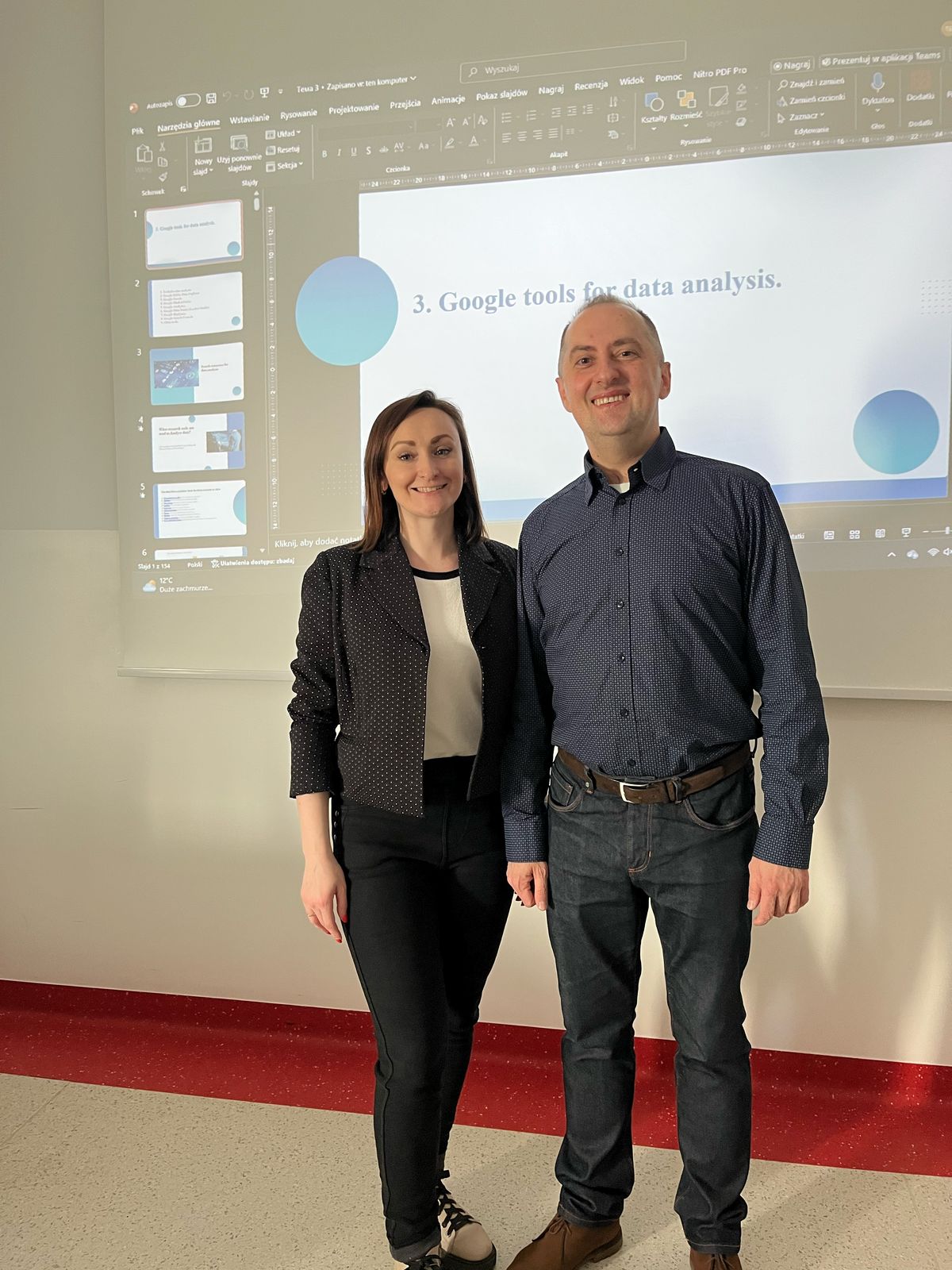 Prof. Piatnychuk z wykładowcą Wydziału Ekonomicznego w sali na tle prezentacji