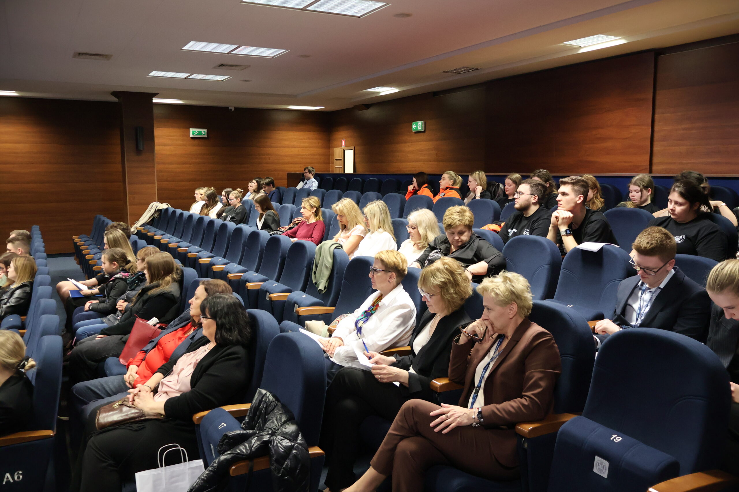 Słuchacze, studenci i pracownicy podczas konferencji.