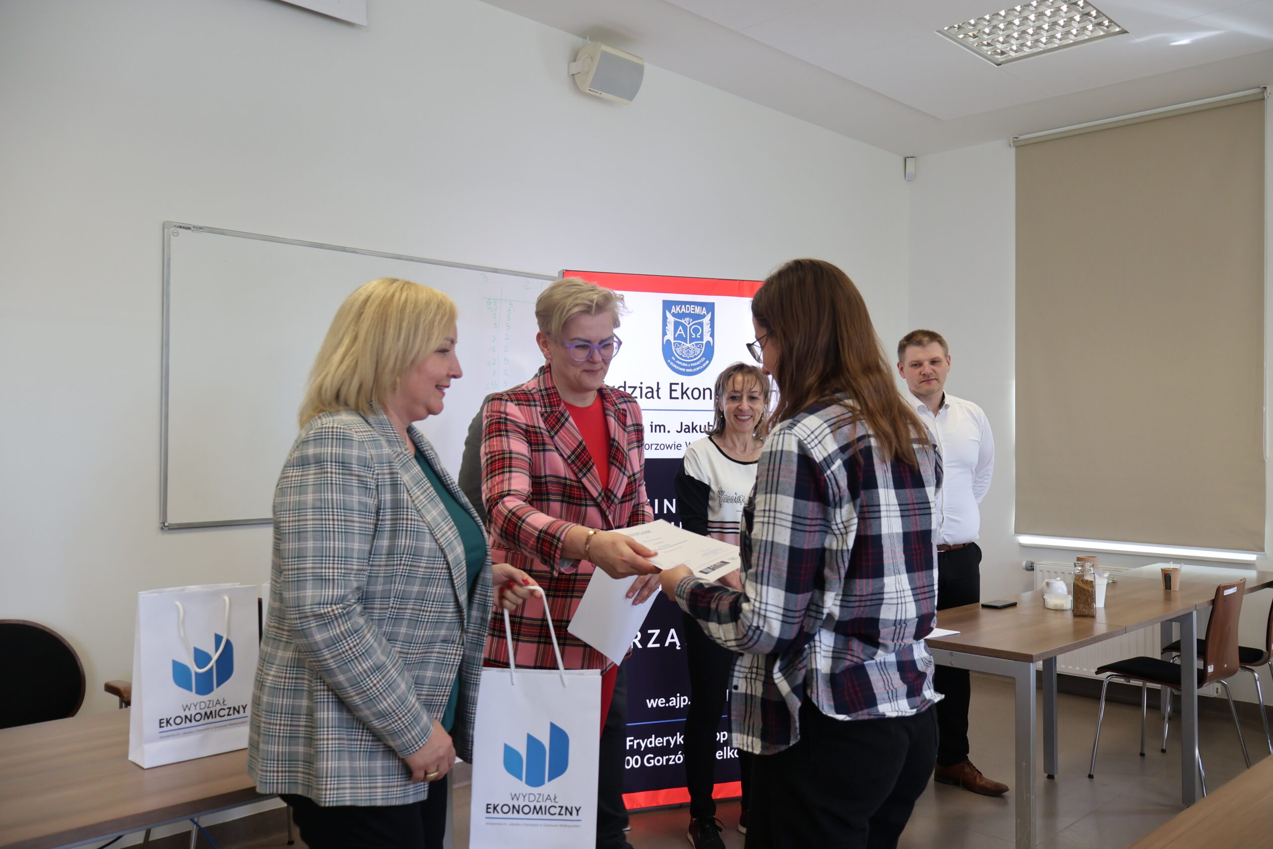 Uczestniczka konkursu odbiera prezent za uczestnictwo w konkursie.