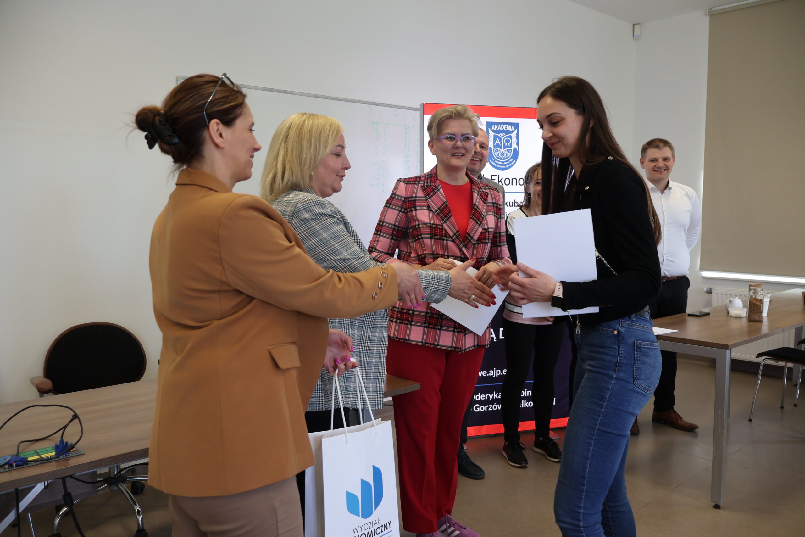 Uczestniczka konkursu odbiera prezent za uczestnictwo w konkursie.