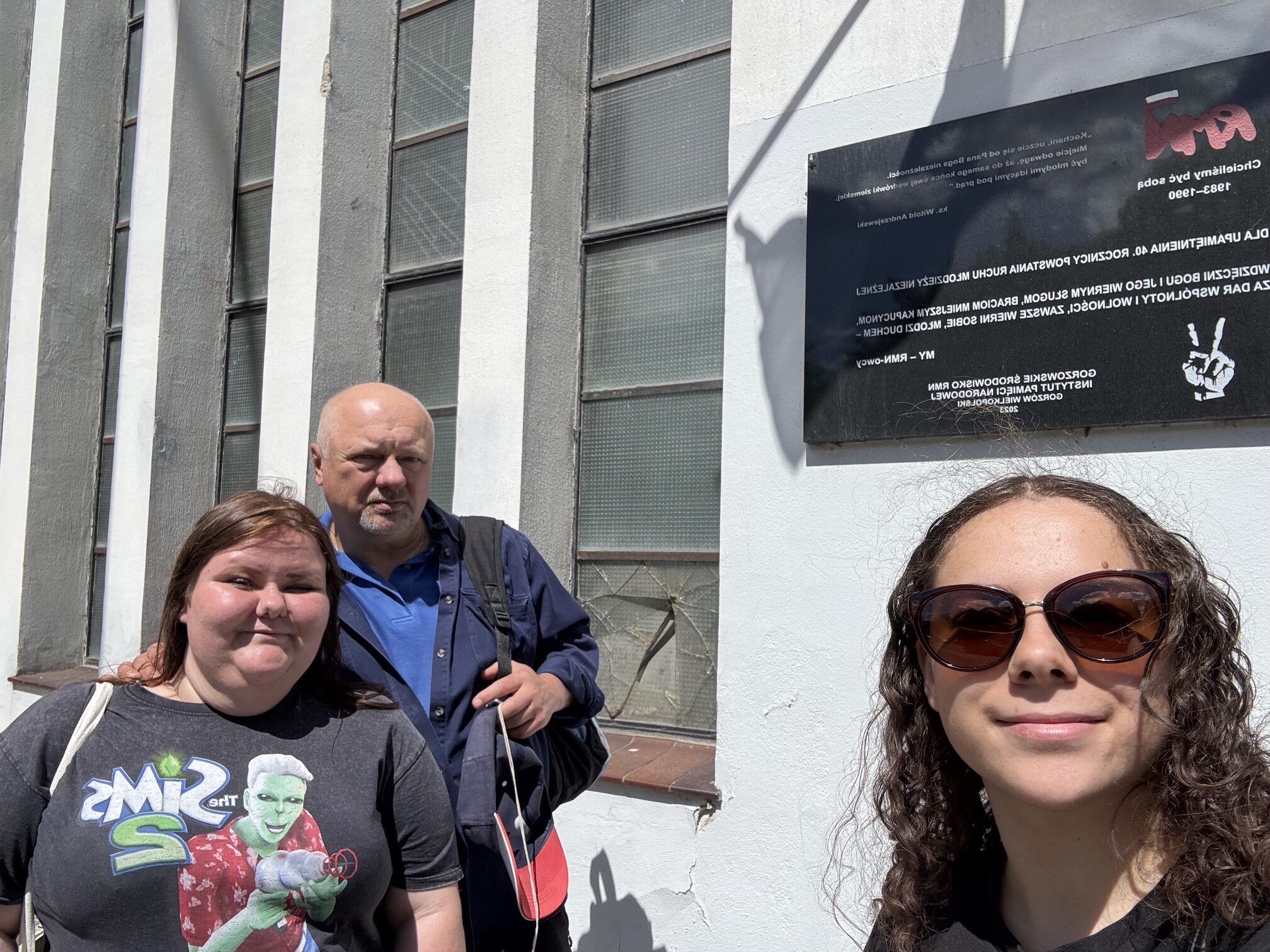Dwie studentki z profesorem Arkadiuszem Wołoszynem przy tablicy upamiętniającej Ruch Młodzieży Niezależnej w Gorzowie Wielkopolskim