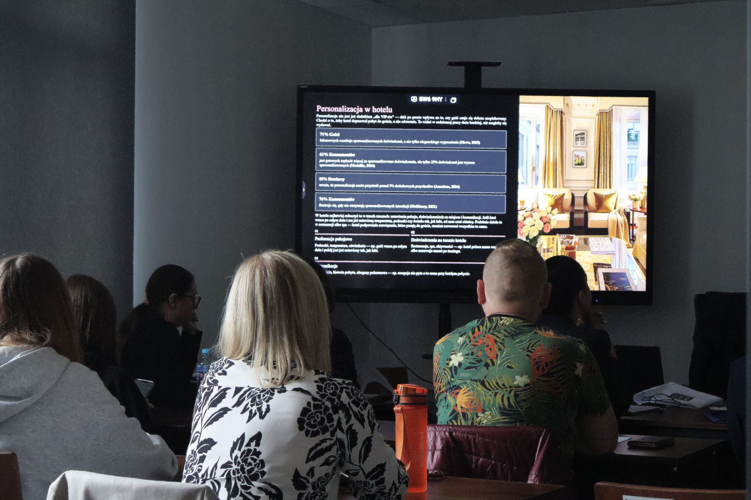 Uczestnicy Seminarium siedzą i oglądają prezentację
