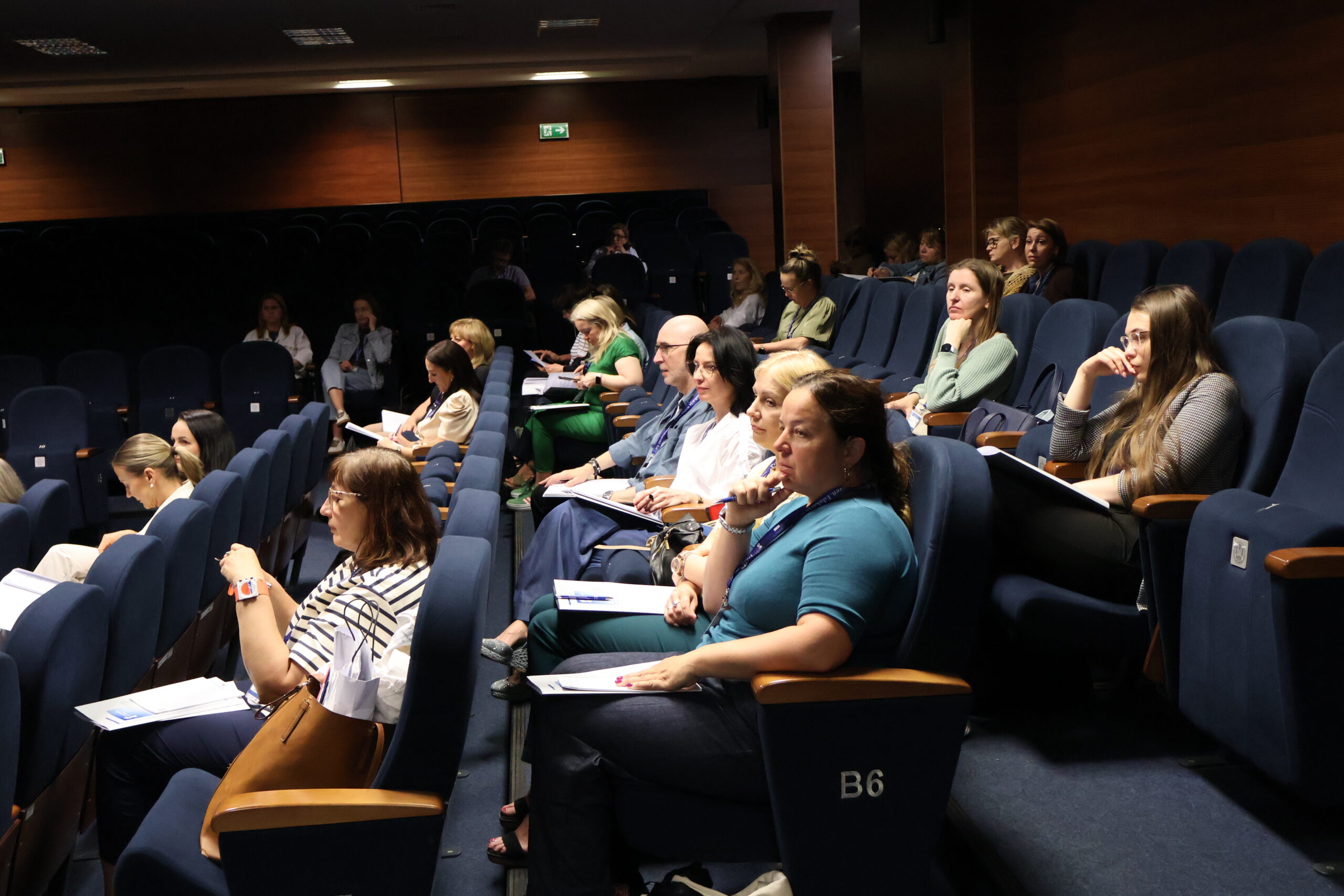 Uczestnicy konferencji siedzą w Auli i słuchają wykładu