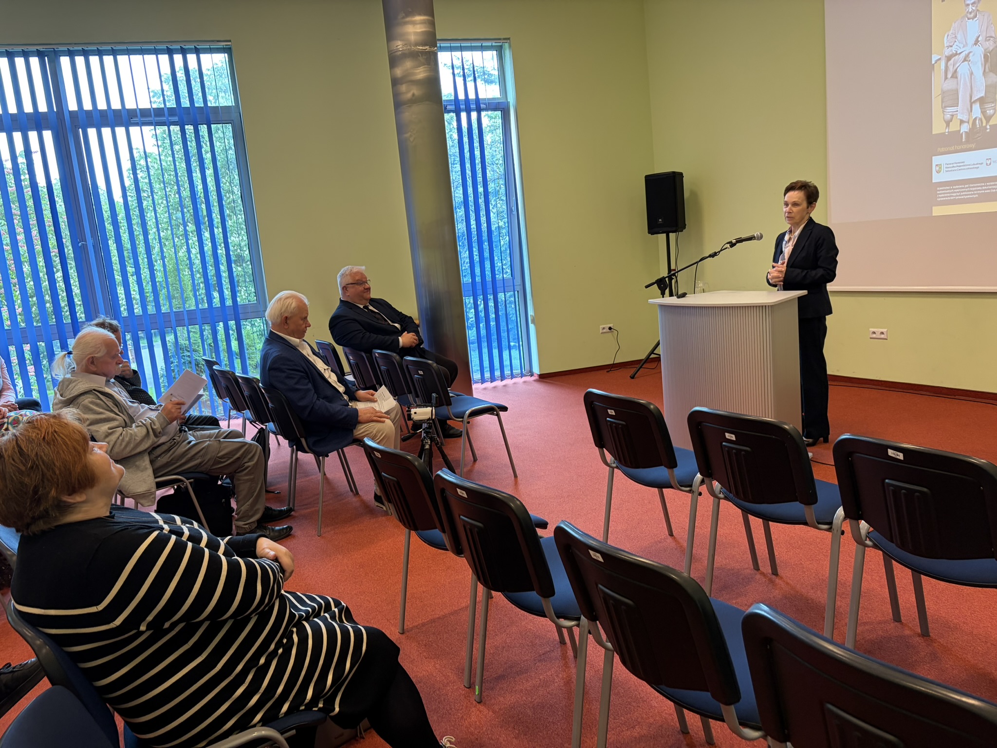 JM Rektor prof. dr hab. Elżbieta Skorupska-Raczyńska przemawia podczas Ogólnopolskiej Konferencji Naukowej z okazji 110. rocznicy urodzin Eugeniusza Paukszty. w tle siedzą zgromadzeni goście.