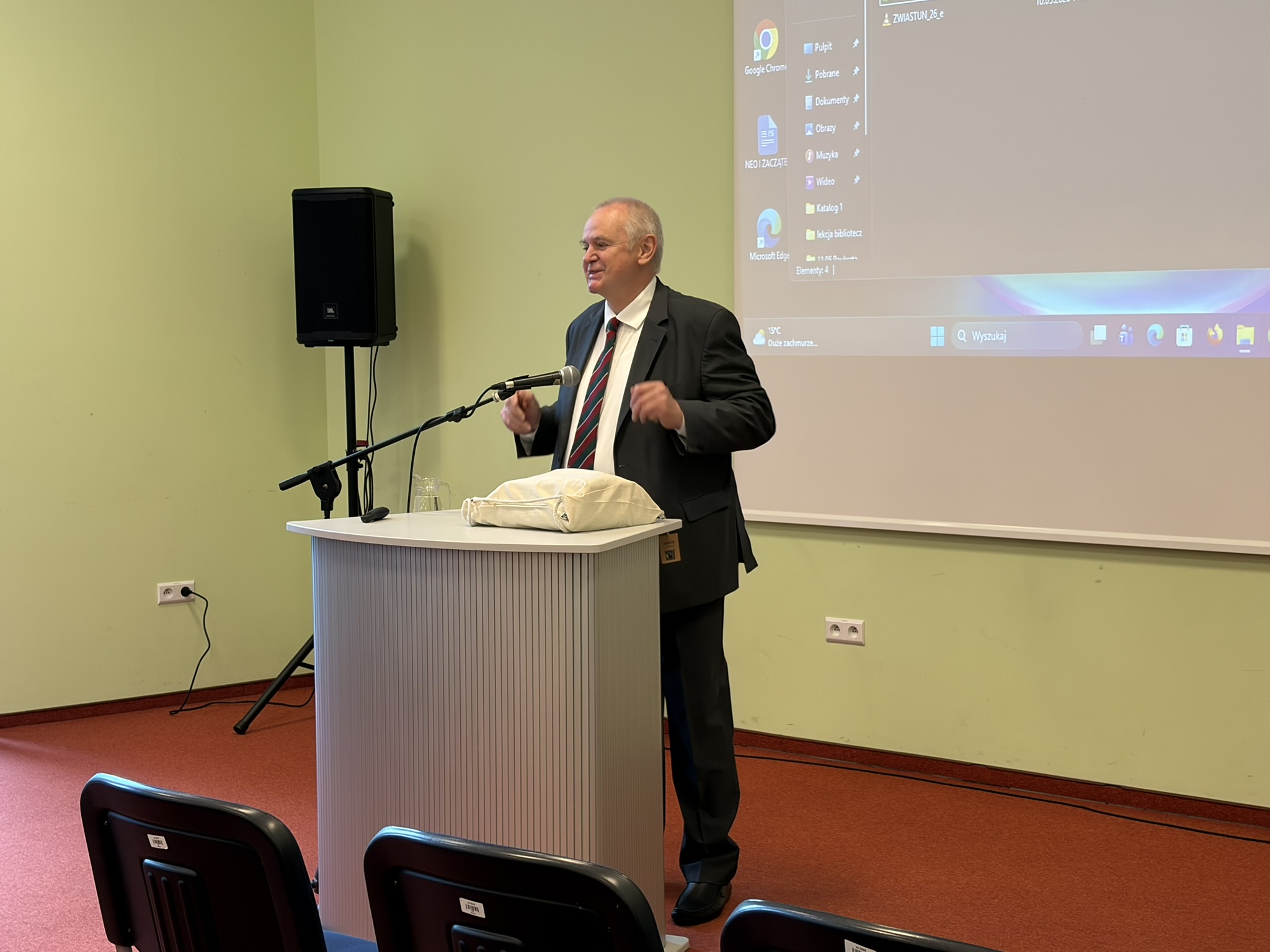 Prelegent podczas wystąpienia z uśmiechem prezentuje swój temat podczas konferencji