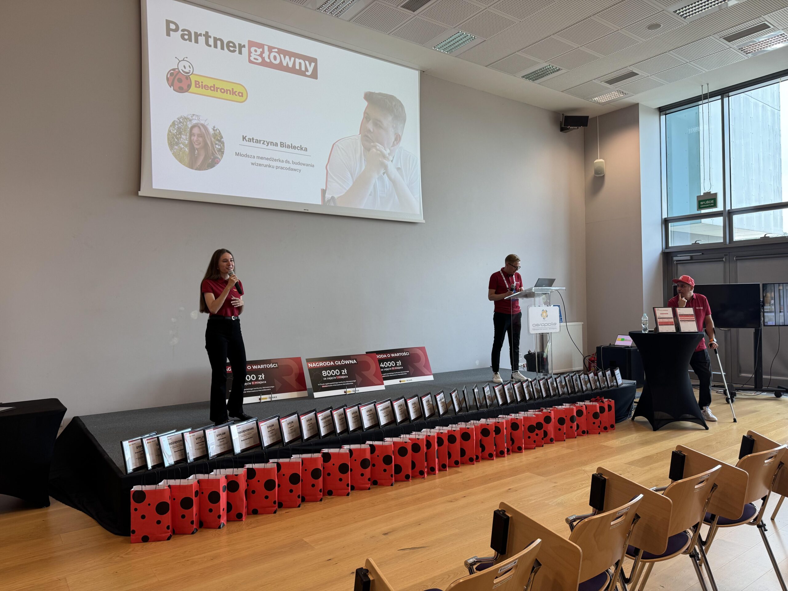 Prowadząca Akademickich Mistrzostw Menedżerskich 2026 stoi na scenie.