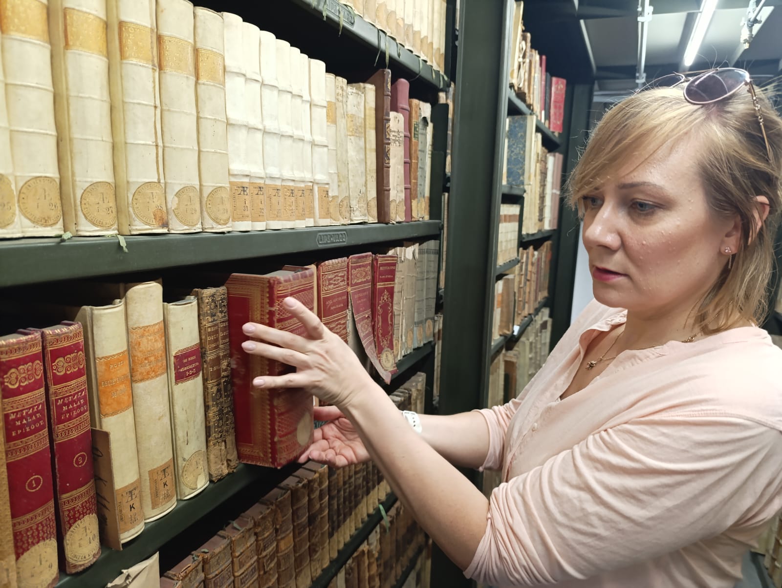 21. Doktorantka wyjmuje książkę z regału